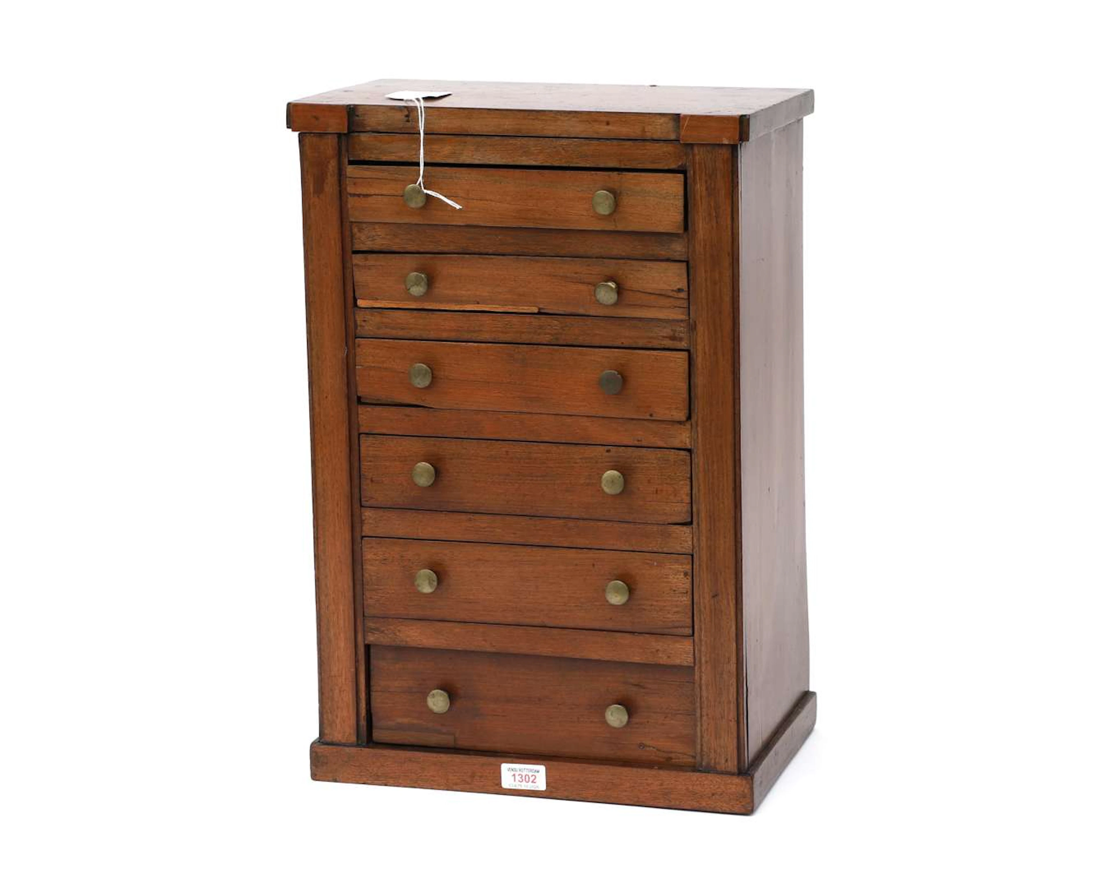 A small wooden chest of drawers, table-sized, 20th century