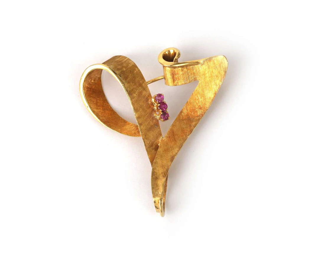 An 18k yellow gold retro brooch with a ruby