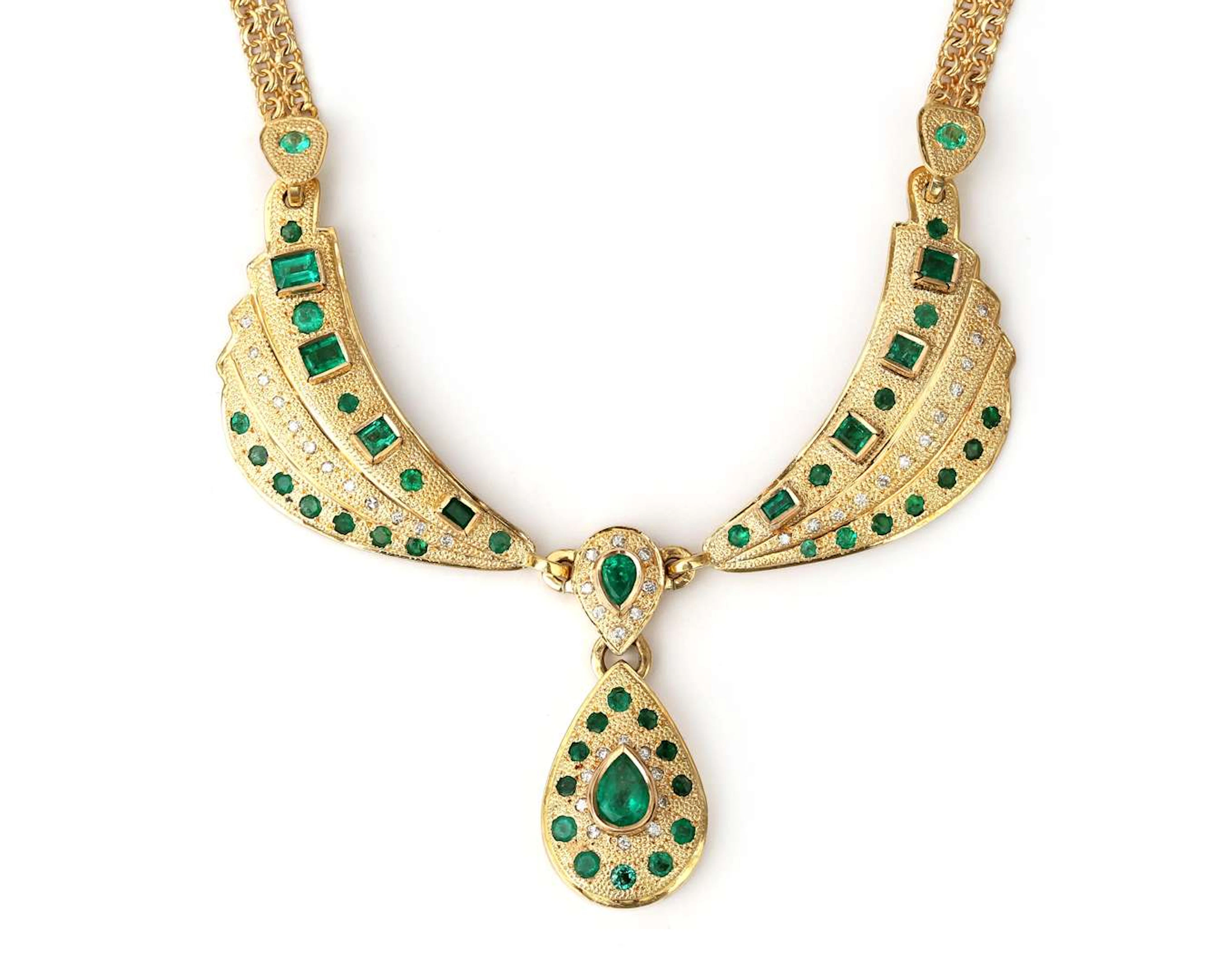 A 14k yellow gold necklace with a diamond and an emerald