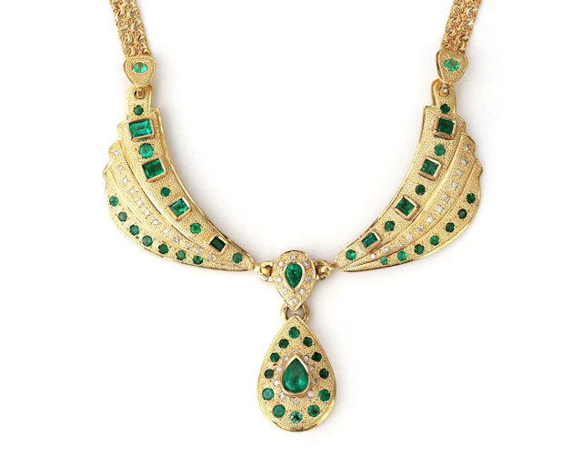 A 14k yellow gold necklace with a diamond and an emerald