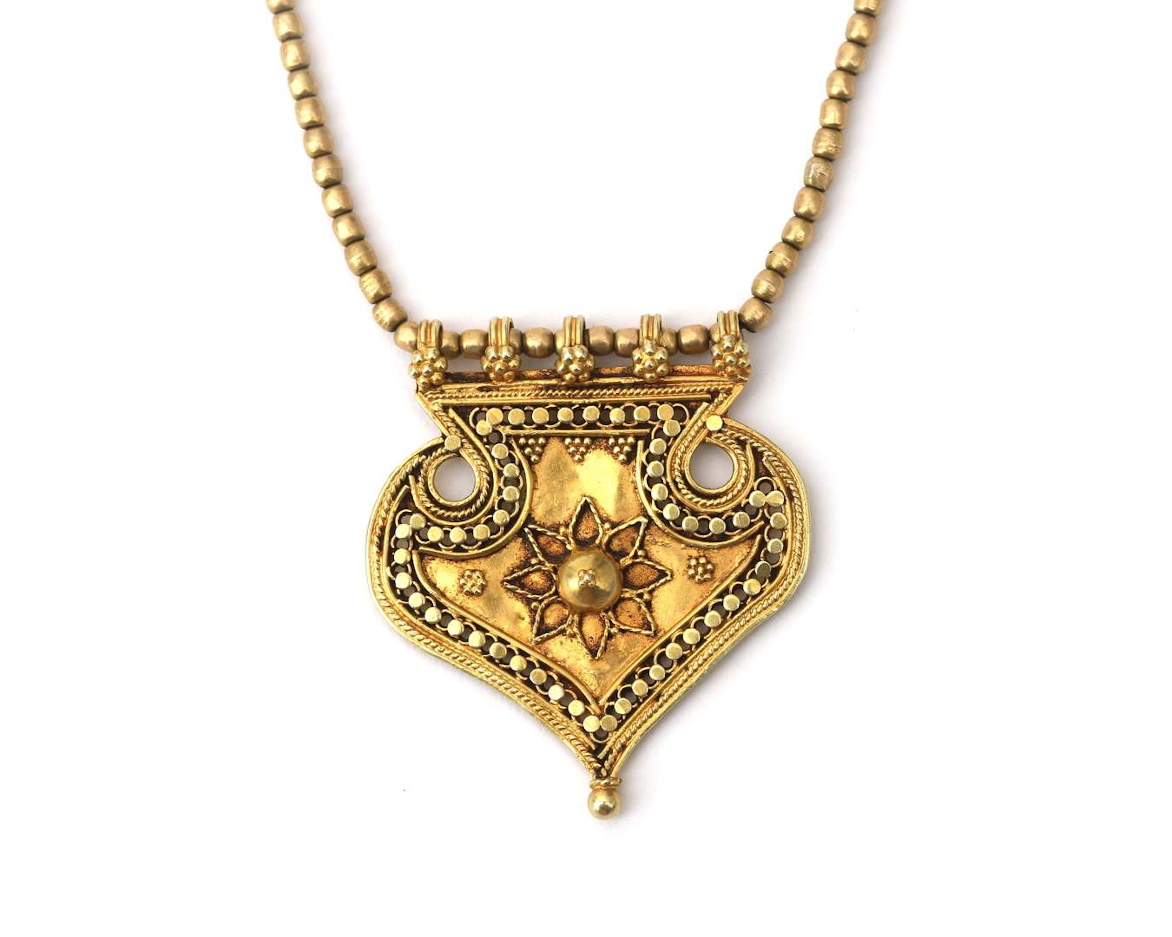 An 18k yellow gold necklace with an Indian heart pendant