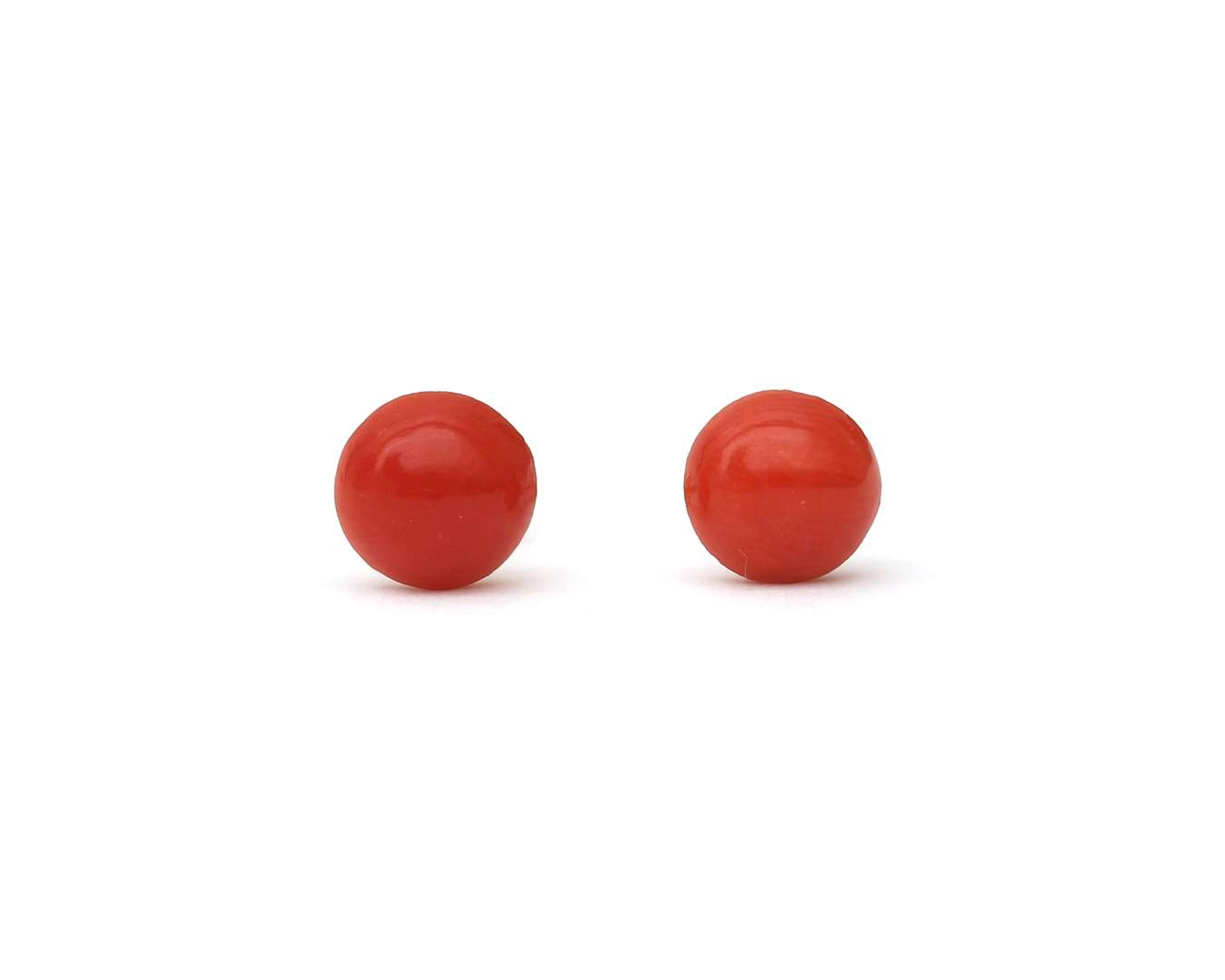 A pair of 18k rose gold stud earrings with red coral