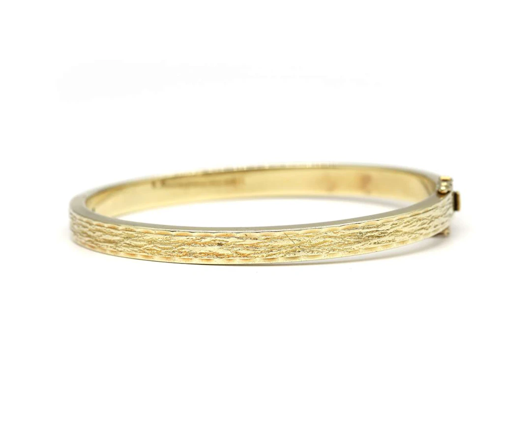 A 14k yellow gold bangle bracelet