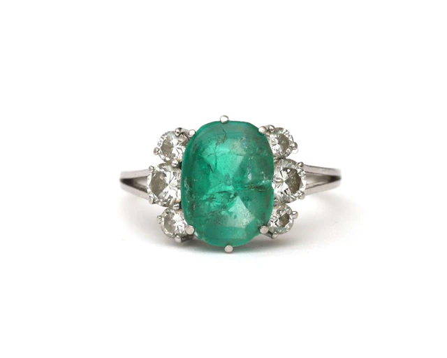 A 14k white gold ring set with an emerald and diamonds