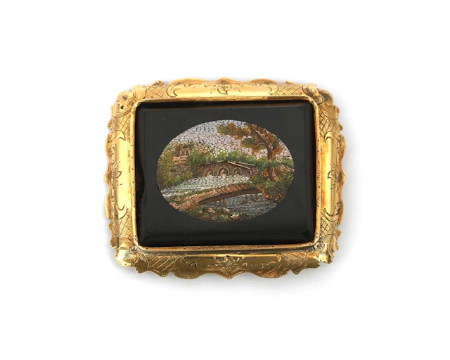 A 14k yellow gold brooch featuring a micro-mosaic of a landscape with a bridge