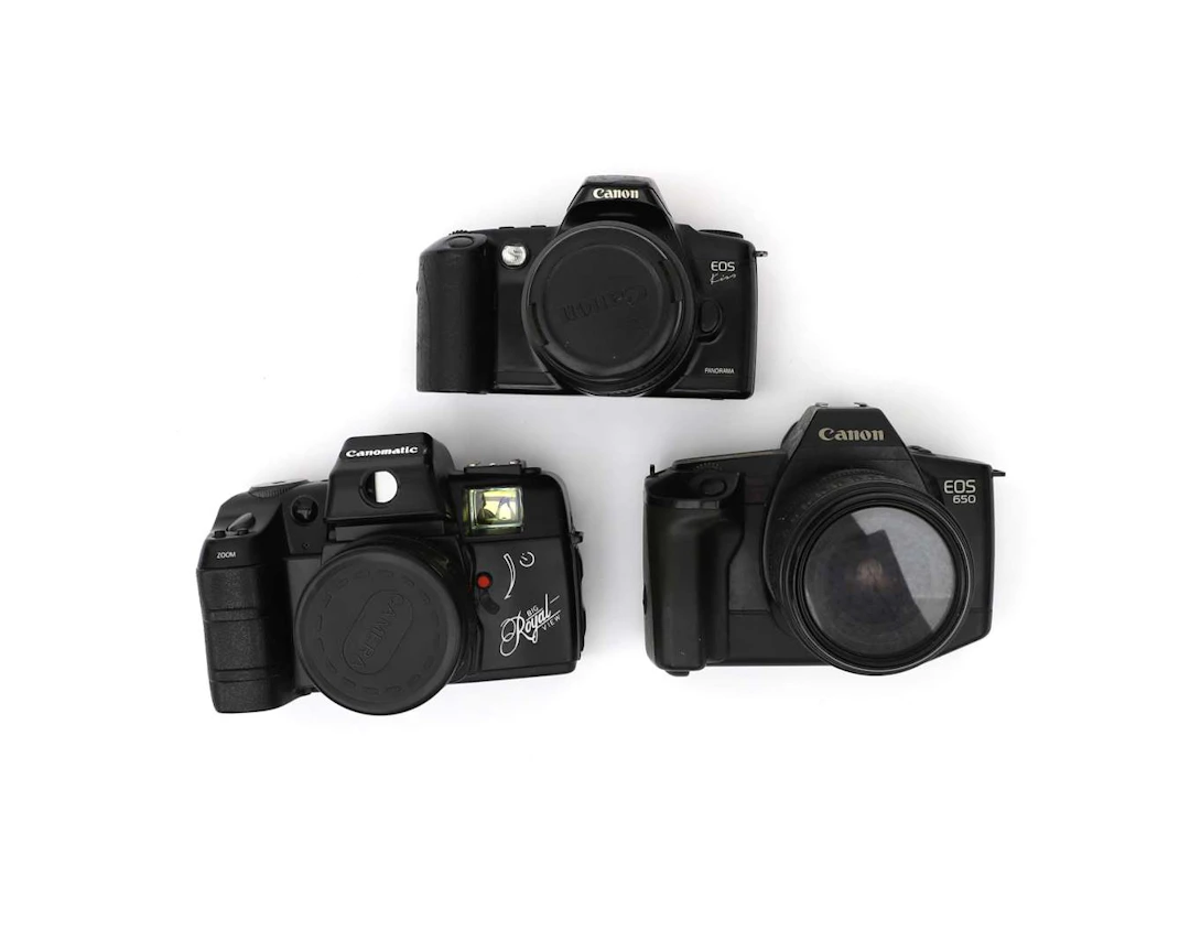Three Canon 35mm cameras with lenses