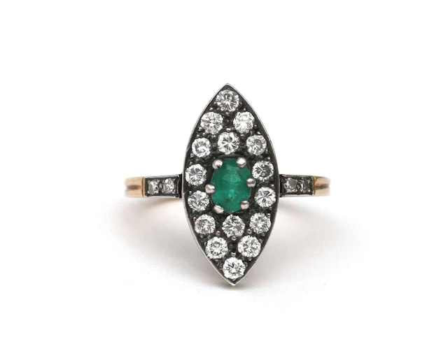 A 14k yellow gold and silver ring set with an emerald and a diamond