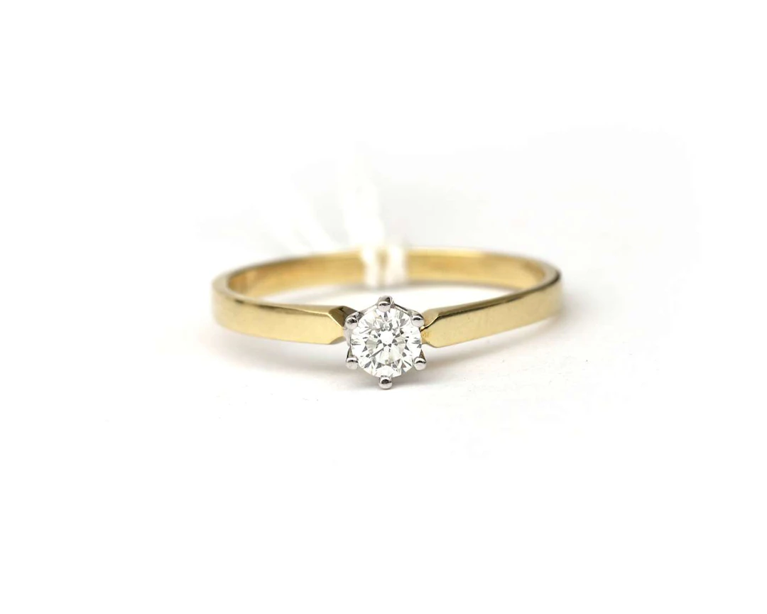 A 14k yellow gold solitaire ring with diamonds