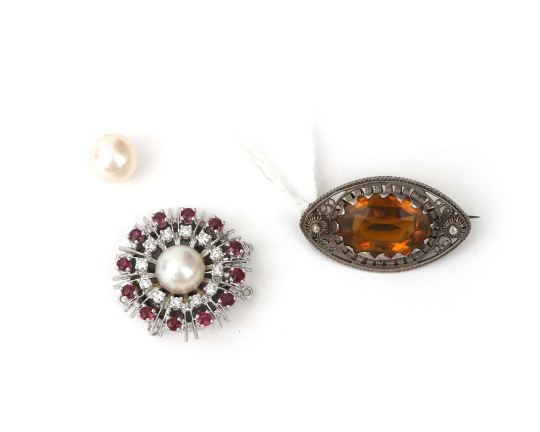 A 14k white gold clasp set with a ruby and a diamond, a brooch and