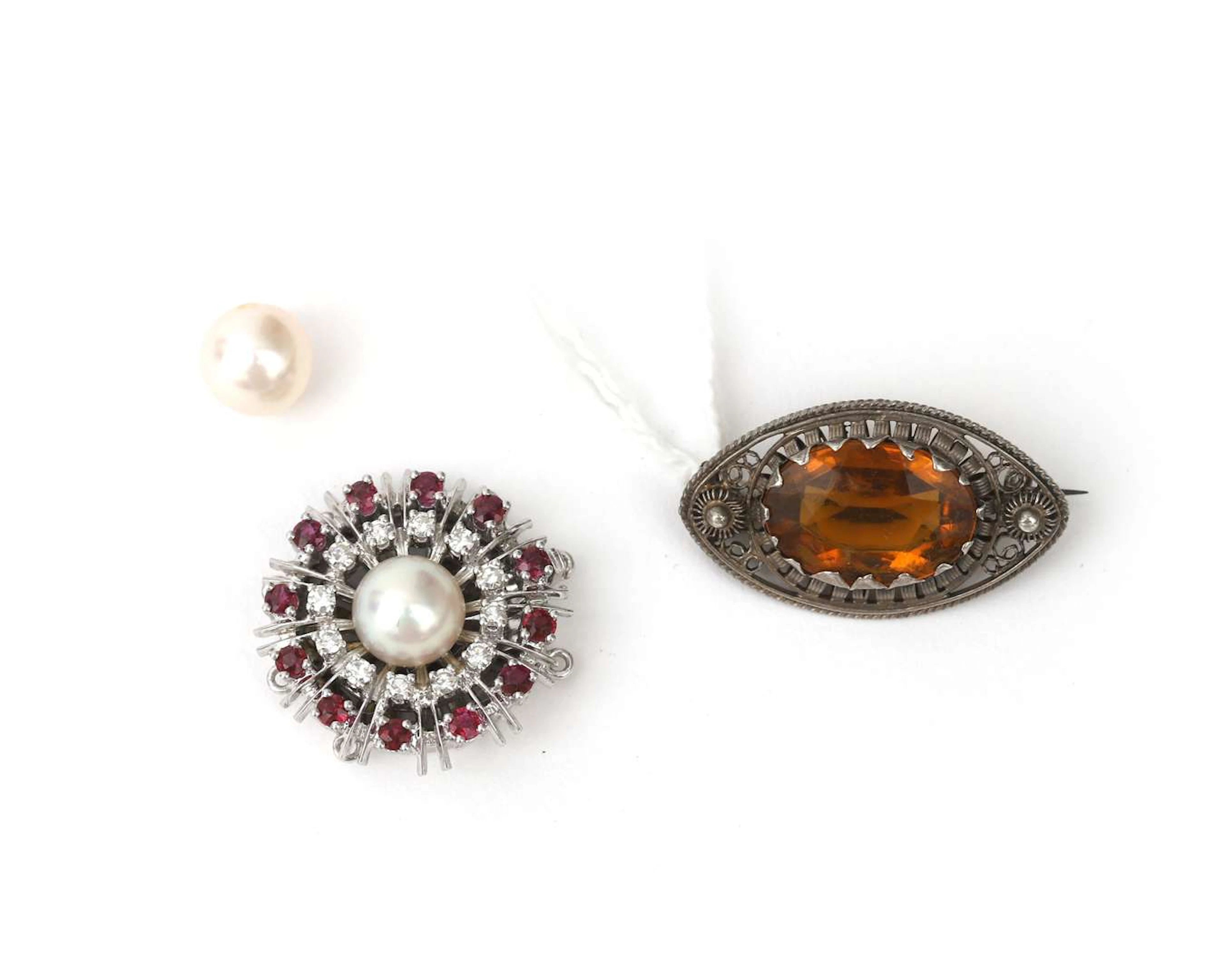 A 14k white gold clasp set with a ruby and a diamond, a brooch and