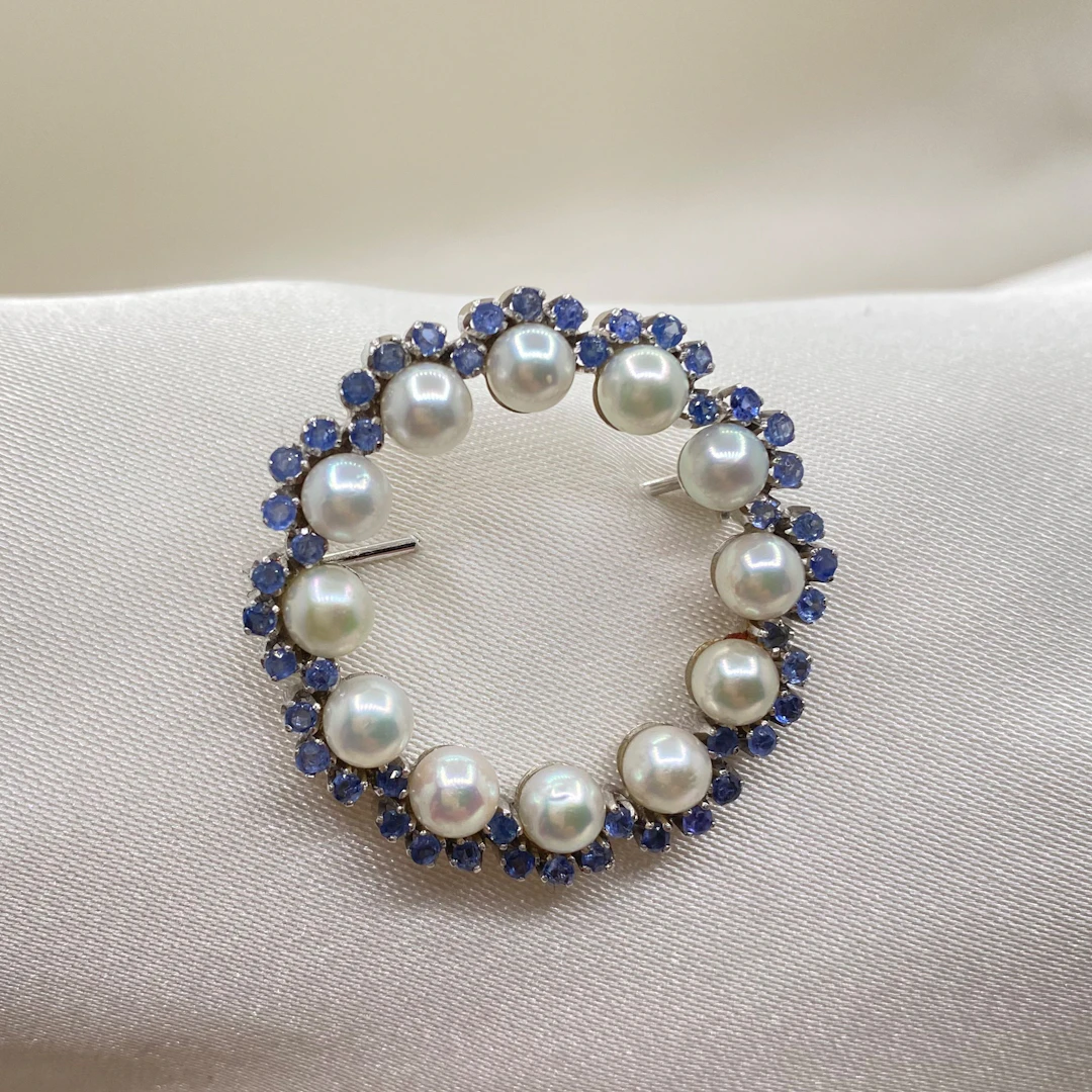 Elegant brooch in 18k white gold with Akoya pearls and blue sapphires