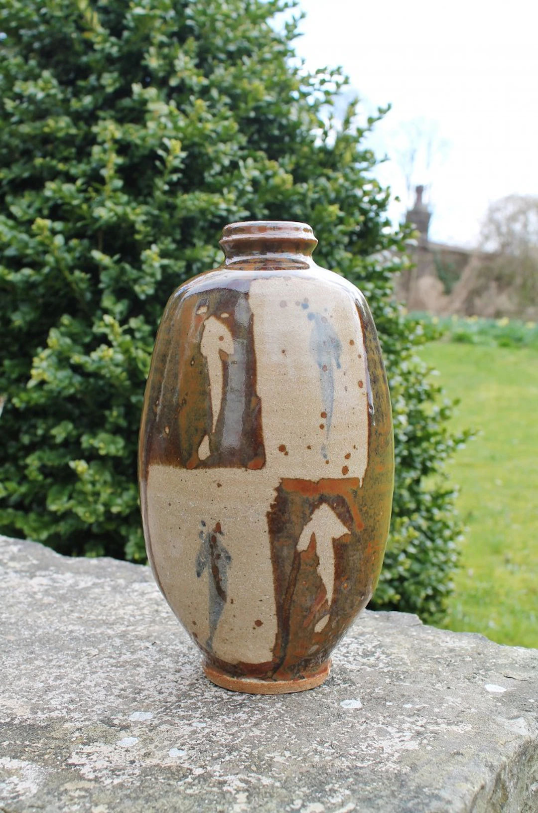 Footed bottle, flattened, wax resist and cobalt , kaki glaze by Jim Malone