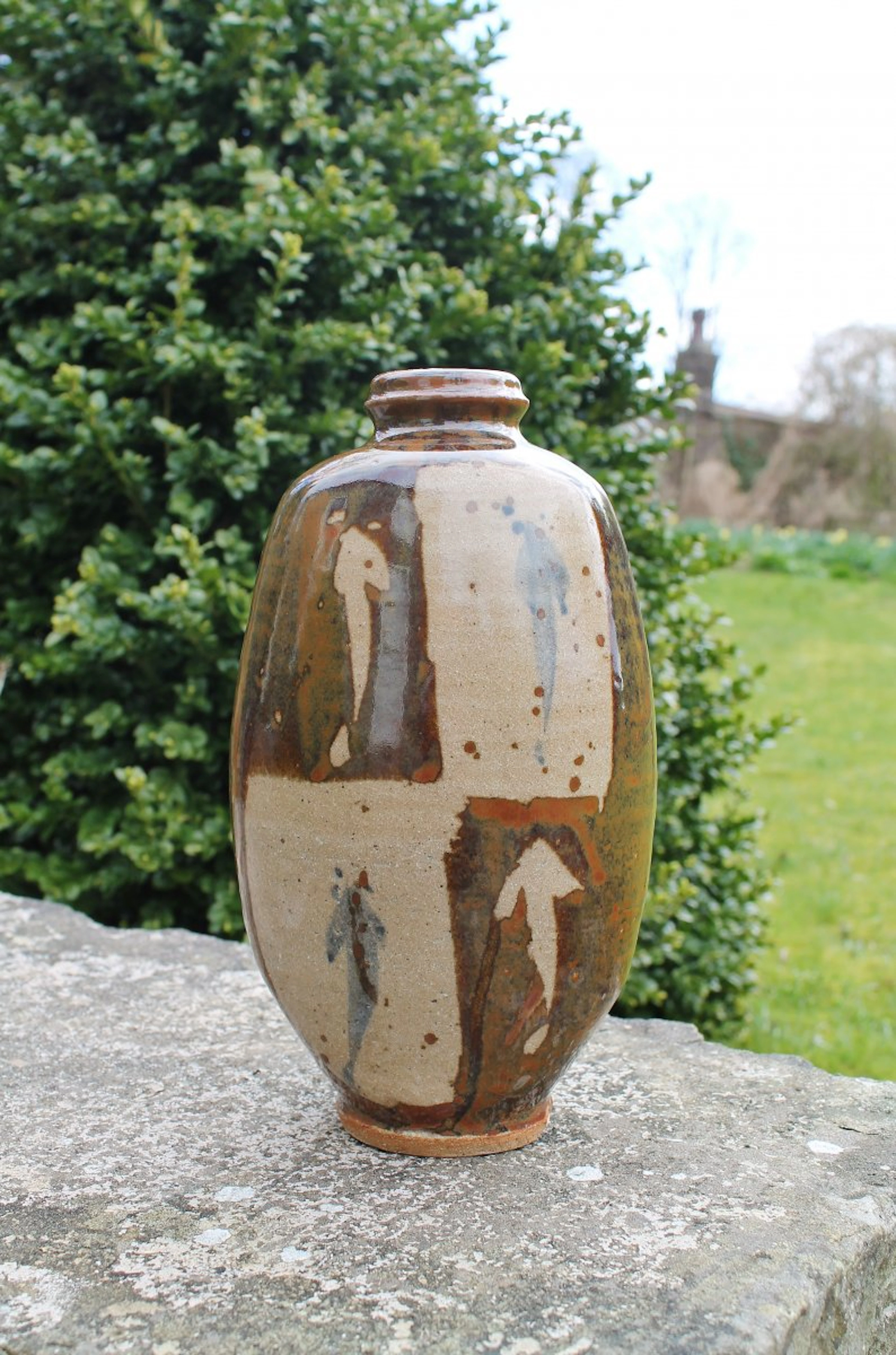Footed bottle, flattened, wax resist and cobalt , kaki glaze by Jim Malone