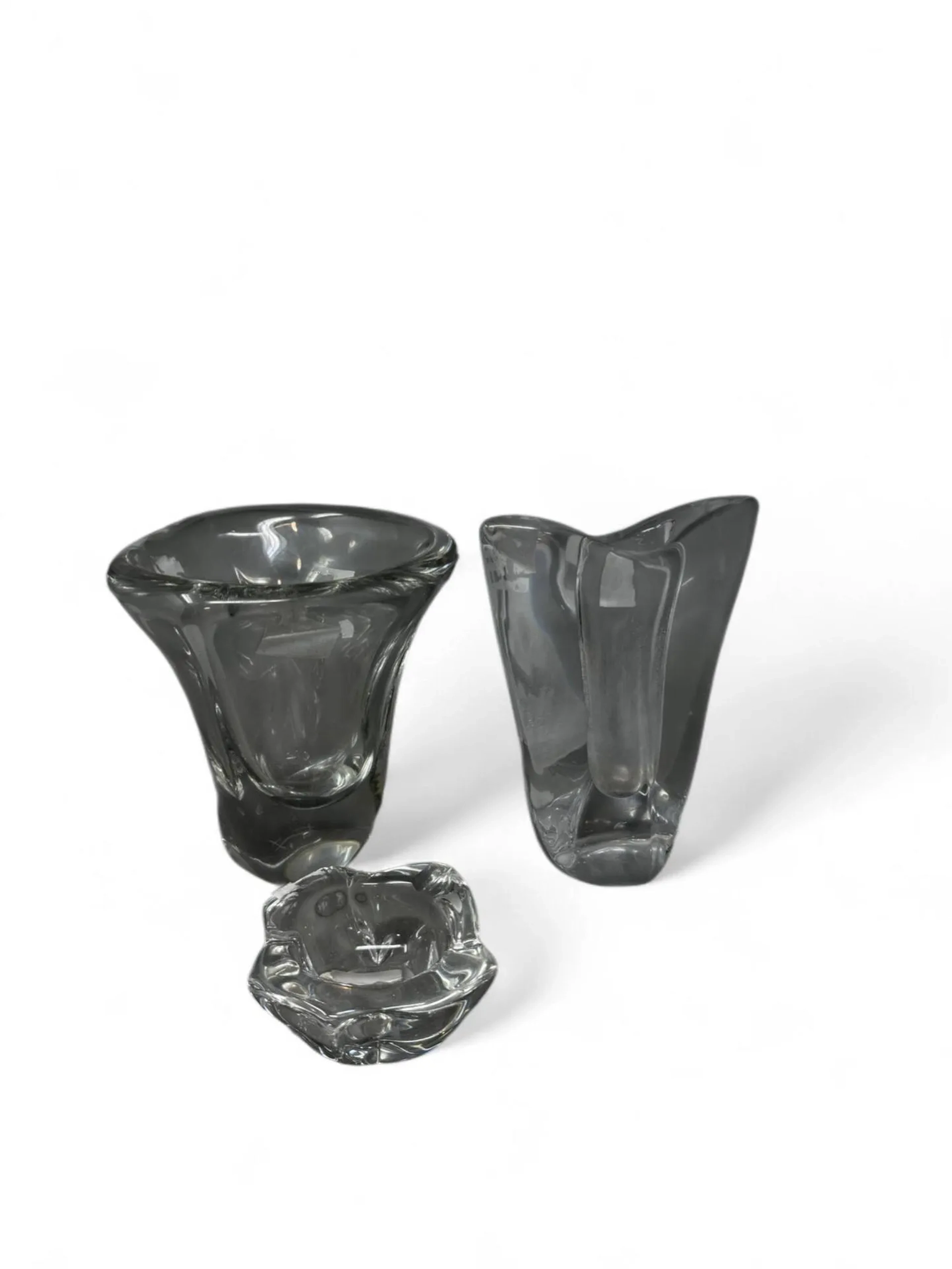 Un ensemble de verrerie Daum France, comprenant deux vases et un cendrier exM14229/50 incomplet