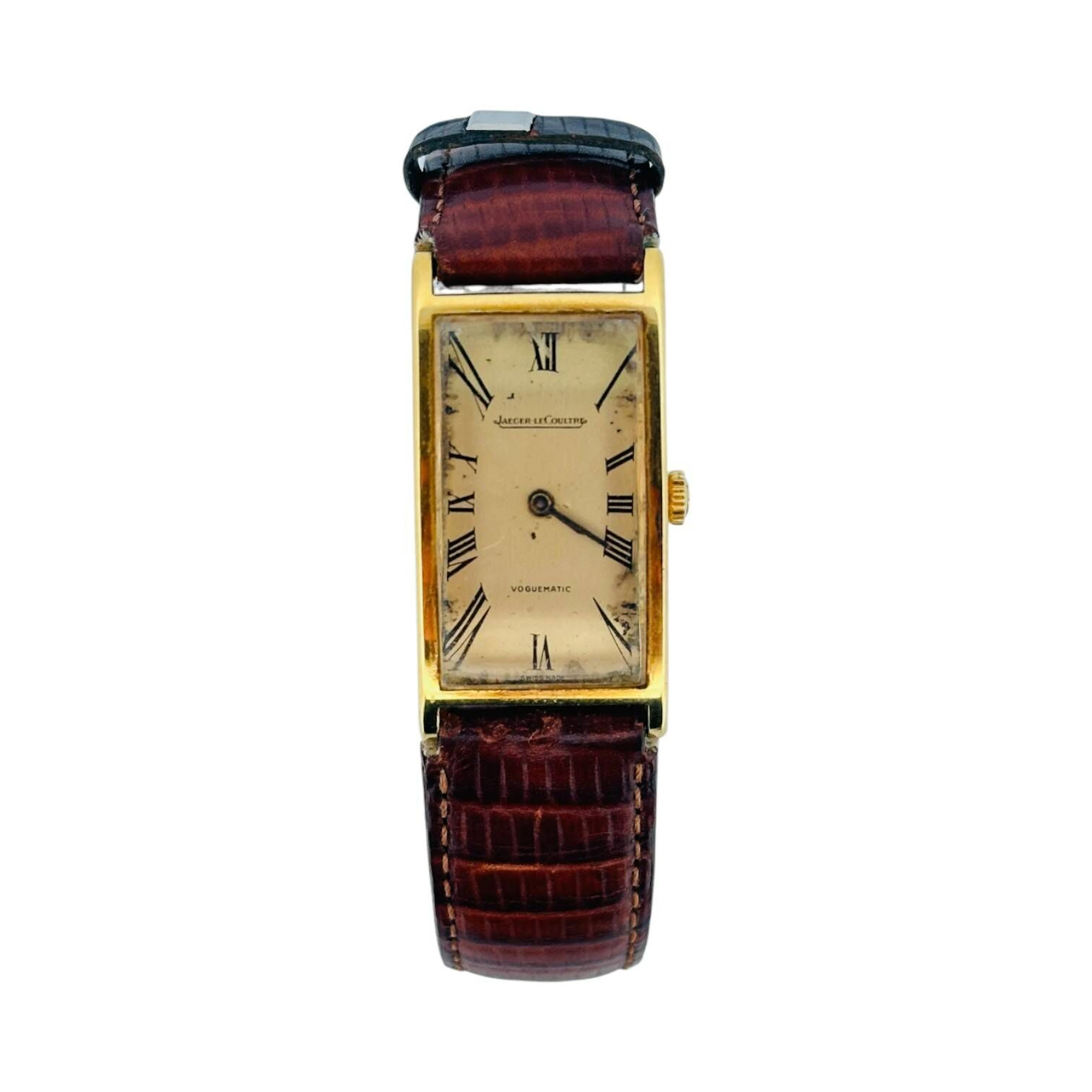 JAEGER-LECOULTRE VOGUEMATIC Montre-bracelet en or 18K (750 millièmes), cadran doré, indexchiffres romains en décalques noires, aiguilles fils noires. Fond clipé en or 18K (750 millièmes)numéroté 1266767 A, à l’intérieur signé LeCoultre Co, fabrication A. Bräuchi & fils (poinçon tête de marteau 206). Mouvement mécanique à remontage automatique signé Jaeger-LeCoultre, calibre 832/1, numéroté. Bracelet en cuir marron, boucle ardillon en métal doré. Montre fonctionnelle lors de l’expertise, sans garantie de fonctionnement futur et d’état des pièces. Rayures au boitier et au verre, marques au cadran. Vers 1970 Poids brut 25,5 g Dimensions 18 x 36 mm