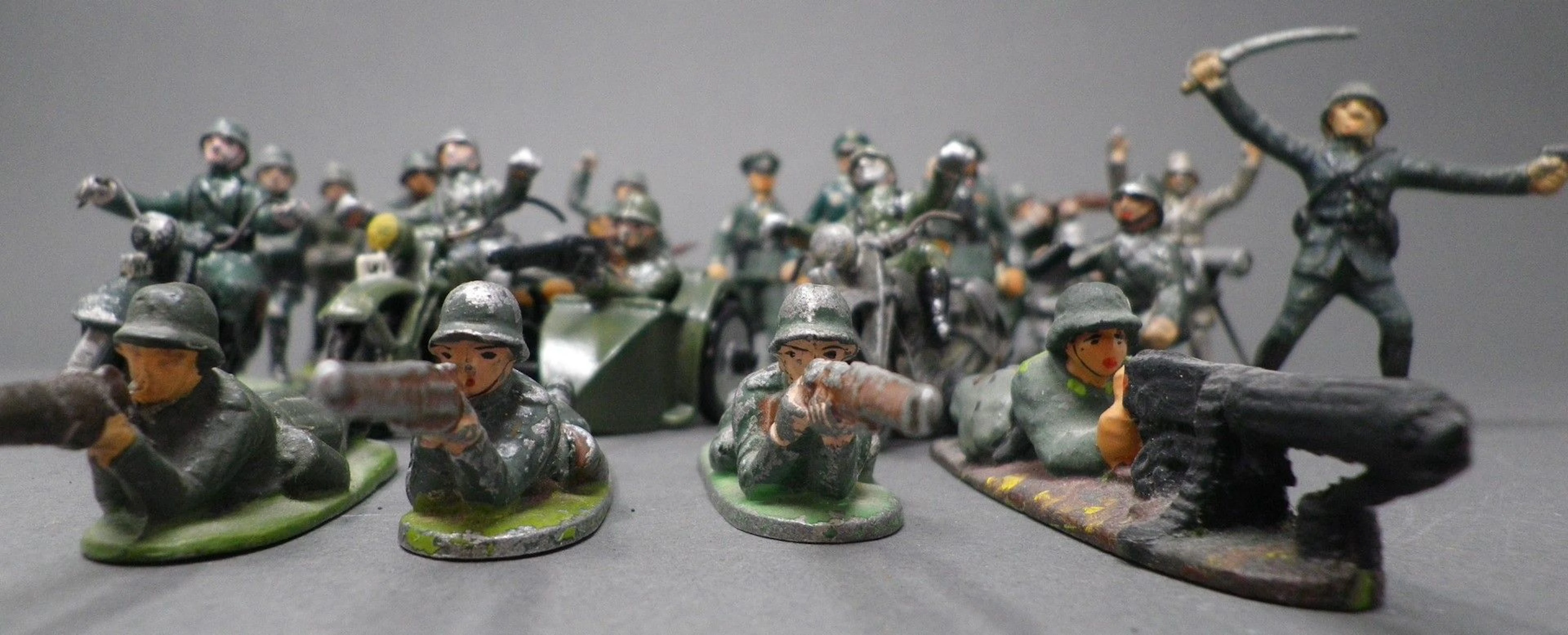 QUIRALU - ARMEE ALLEMANDE (1933-1940) 26 figurines dont : motocyclistes, moto et conducteur avec side-car et passager fusil-mitrailleur, soldats au combat. Bibliographie : p. 121 et 122, Les jouets Quiralu 1933-1964 - R. Alazet - J. Borsarello - H. Giroud - Ed° J. Granchet Paris. Jouets anciens pouvant présenter des manques de peinture, des chocs ou des manques, y compris pour les conditionnements éventuels. Vendus en l'état et sans réclamations.