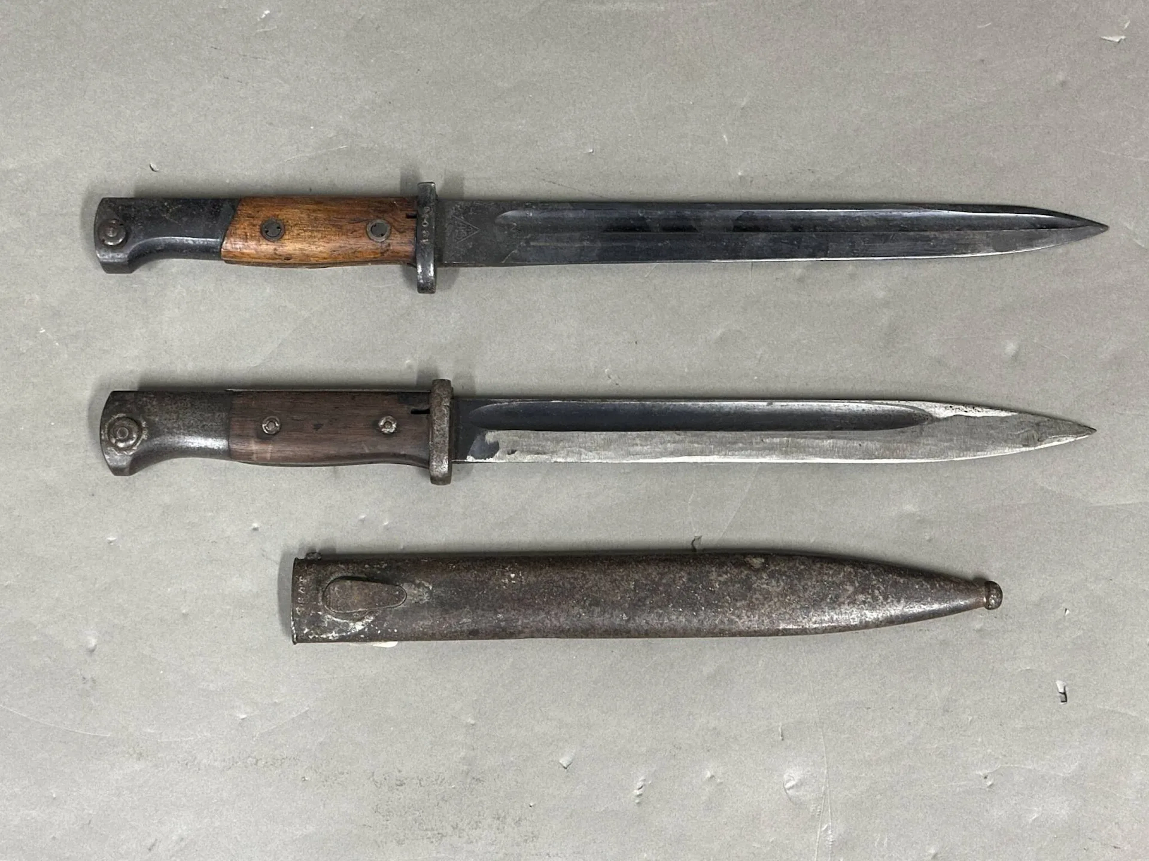 Ensemble de deux baïonnettes. Comprenant une pour fusil Mauser 98k avec fourreau (oxydations). La seconde sans fourreau.