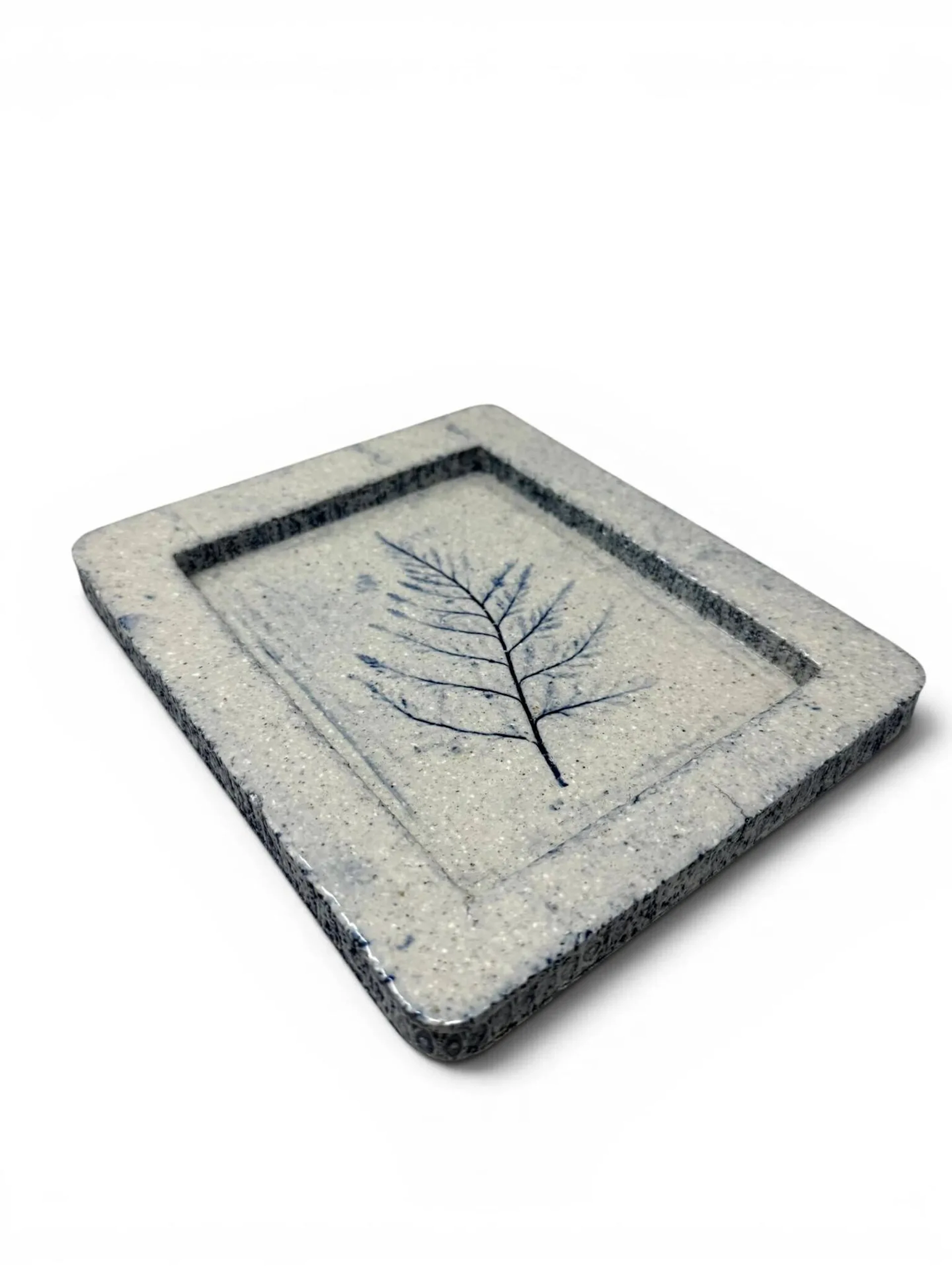 ROGER CAPRON (1922-2006) Vide-poche, circa 1970 Épreuve en grés émaillé gris bleu, à décor d’un feuillage Porte le cachet Capron Vallauris France sur l’envers H. : 2.5 cm. - L. : 18.7 cm. - P. : 16 cm.