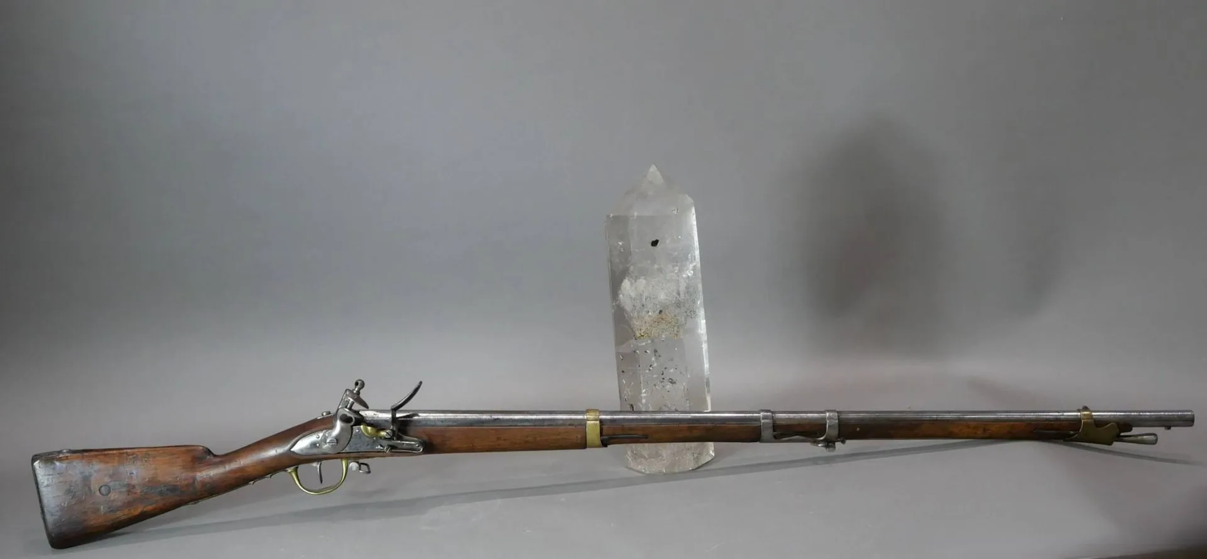 Fusil de dragon modèle an 9. Platine à silex de la manufacture de Charleville. Canon à pas puis rond daté 1810 au tonnerre et reste de marquage an 9 à la queue de culasse. Crosse en noyer (xylophages et fut légèrement raccourci) et garnitures en fer et laiton, contre-platine marquée AP. Piqures, bonne mécanique. Baïonnette à douille complète de son fourreau en cuir à deux garnitures laiton Longueur totale : 143 cm. France, Époque premier Empire. On joint une poire à poudre à corps en cuir et bec en laiton.