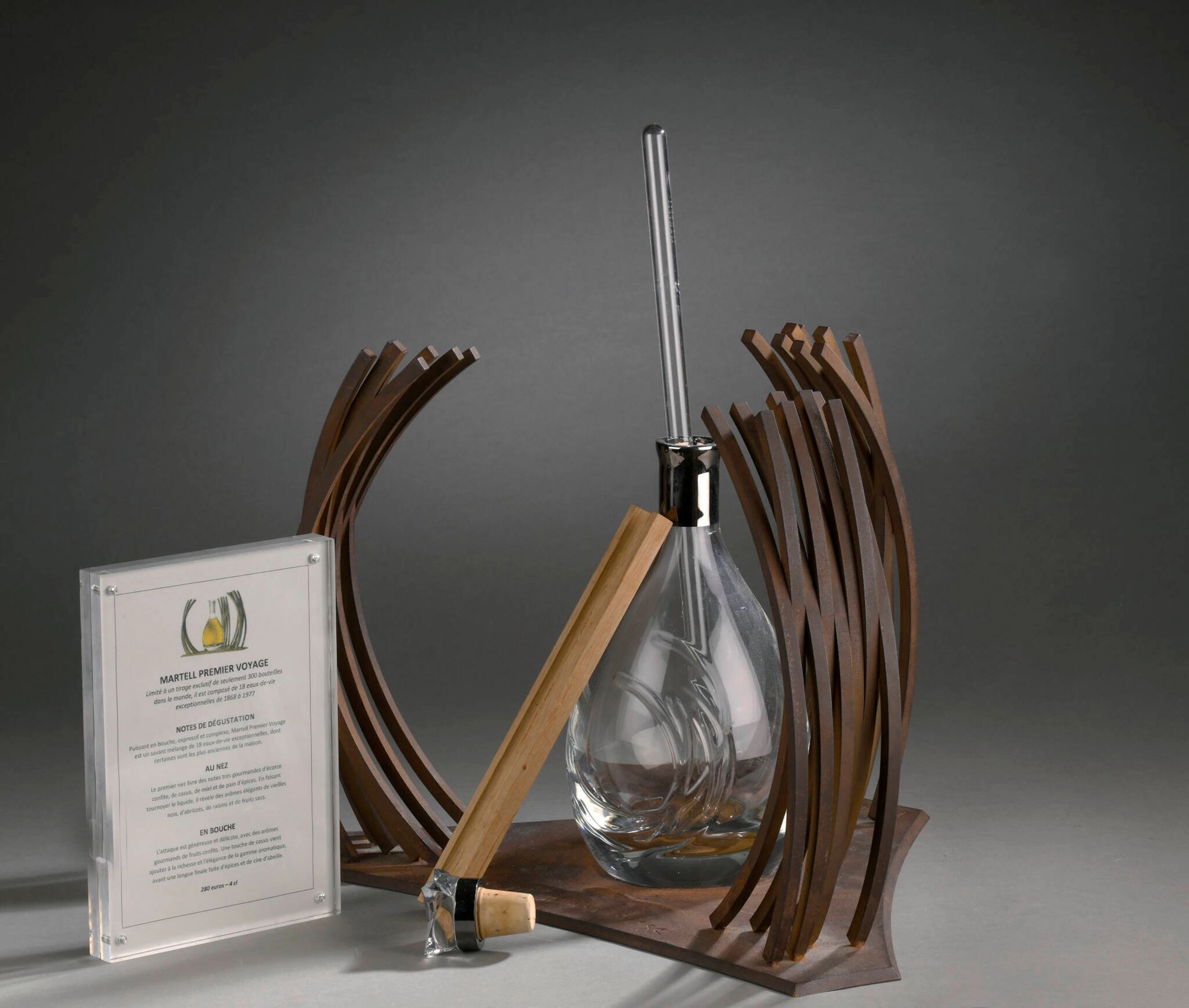VENET Bernar, né en 1941 Martell Premier Voyage édition en acier plié et soudé n°59/300, avec bouteille en verre (bouteille vide, un petit éclat au bouchon et quelques traces de mouillures à la patine sur la base, sans son coffret) sur la terrasse: B Venet Ht.: 30 cm; Lg.: 45 cm; Prof.: 33 cm