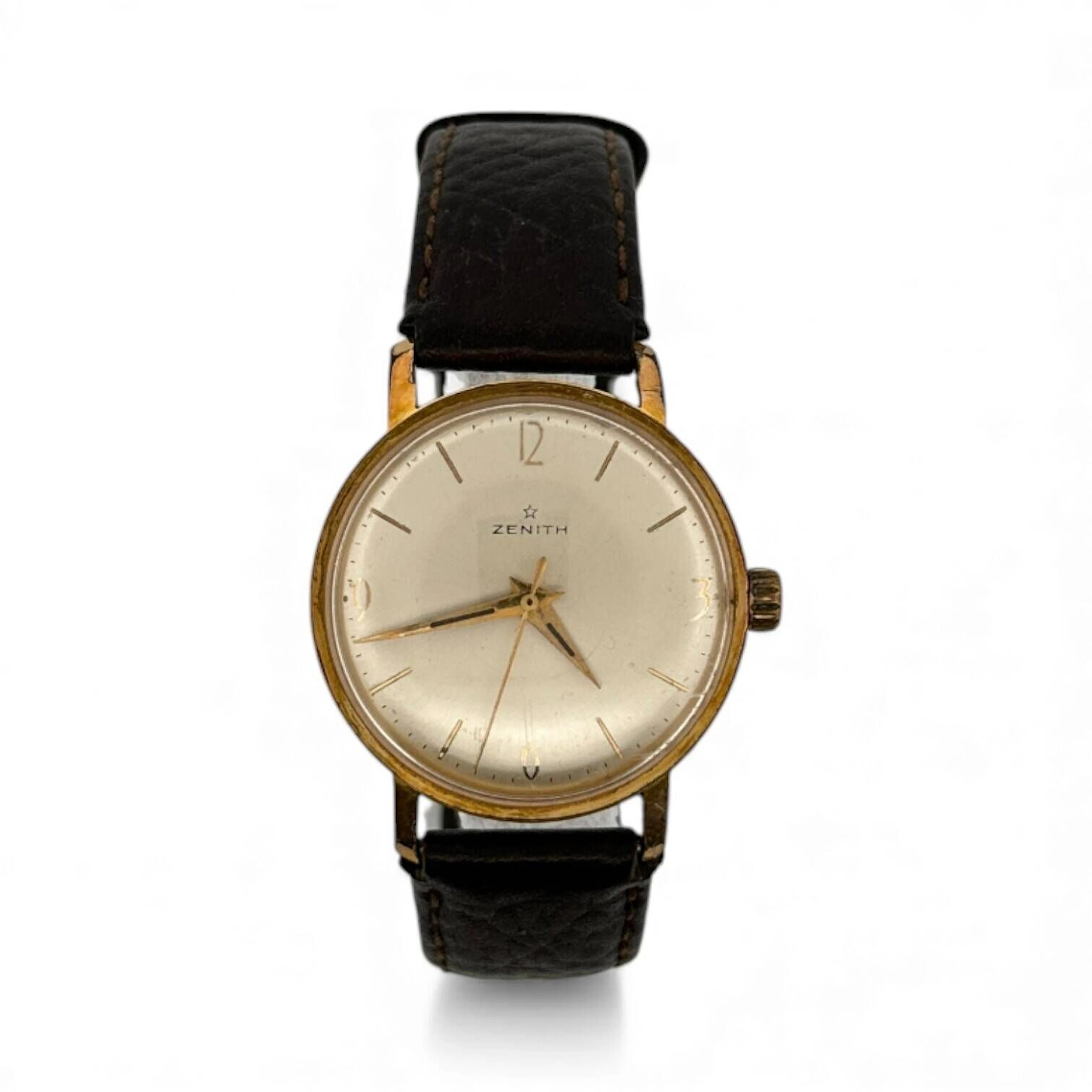 ZENITH Montre bracelet pour homme, boitier rond en acier, lunette dorée, index chiffres arabes aux quarts et bâtons formant les heures, mouvement mécanique. Bracelet en cuir (état d’usage) à boucle ardillon. Fond numéroté 1000594. Fonctionnelle, révision à prévoir.