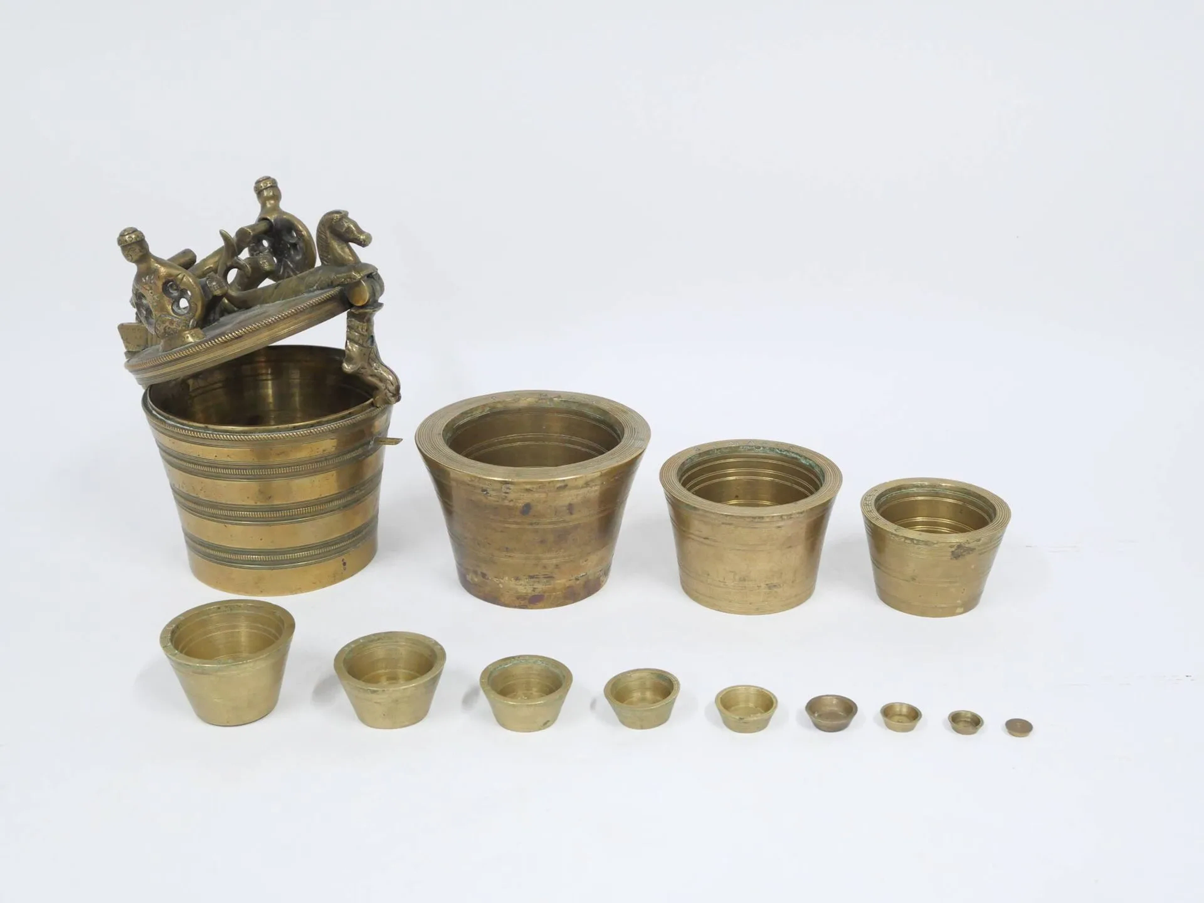 Pile de poids en bronze de 32 Marcs plein dite pile de poids de Charlemagne. Poignée formée de deux serpents de mer affrontés, supportée par deux sirènes à double queues. Deux chevaux marins formant moraillon et son pendant. Allemagne du sud, Nuremberg, fin du XVIIIe siècle Hauteur : 16 cm Poids total : 7,8 kg (réétalonnée par perçage du fond)