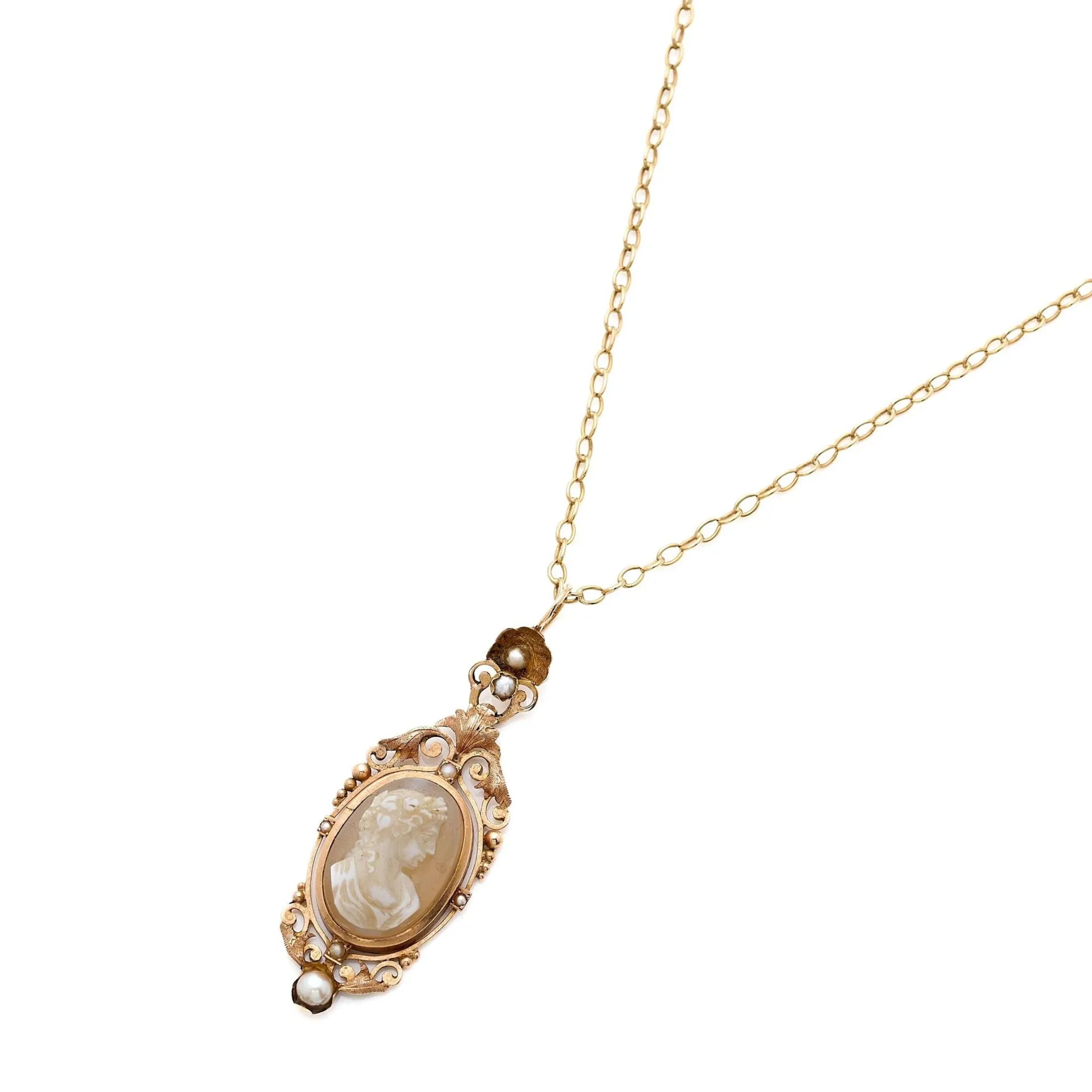 Collier pendentif en or 18k (750e), retenant un camée agate 2 couches figurant le profil d'une femme coiffée dans un entourage de volutes ponctuées de petites perles. Accompagné d'une chaîne maille forçat, fermoir anneau ressort. Travail français du milieu du XIXème siècle pour le pendentif. Poids brut : 9.10 g. Longueur : 49 cm.