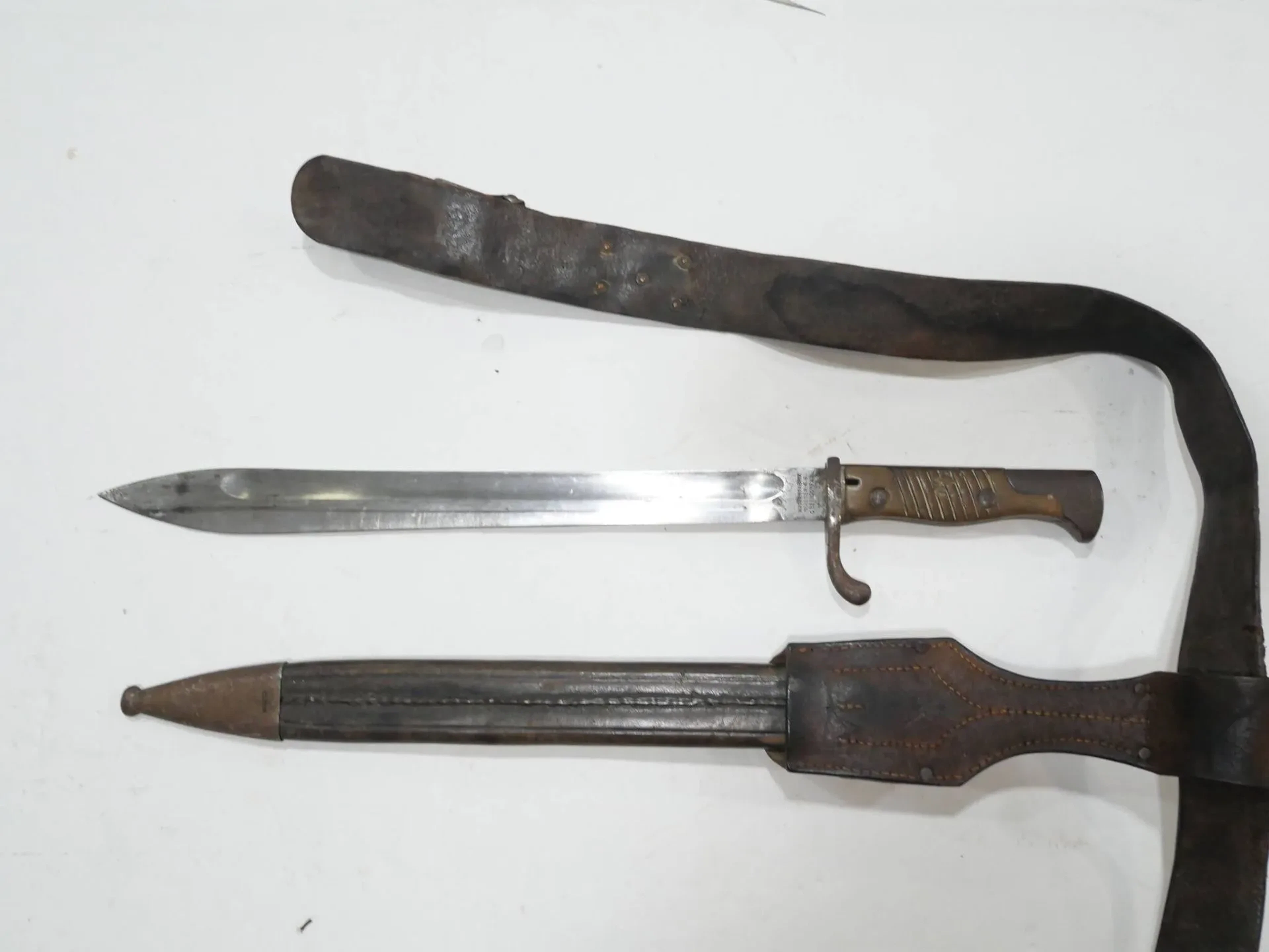 Ensemble première guerre mondiale. Comprenant : -Baïonnette modèle 98-05 pour fusil Mauser. Deuxième type, production waffenfabrick Mauser. Date 1916 et fourreau en cuir à deux garnitures fer. -Gousset en cuir, conforme. -Ceinturon en cuir (EM) avec plateau au règlement 1895.