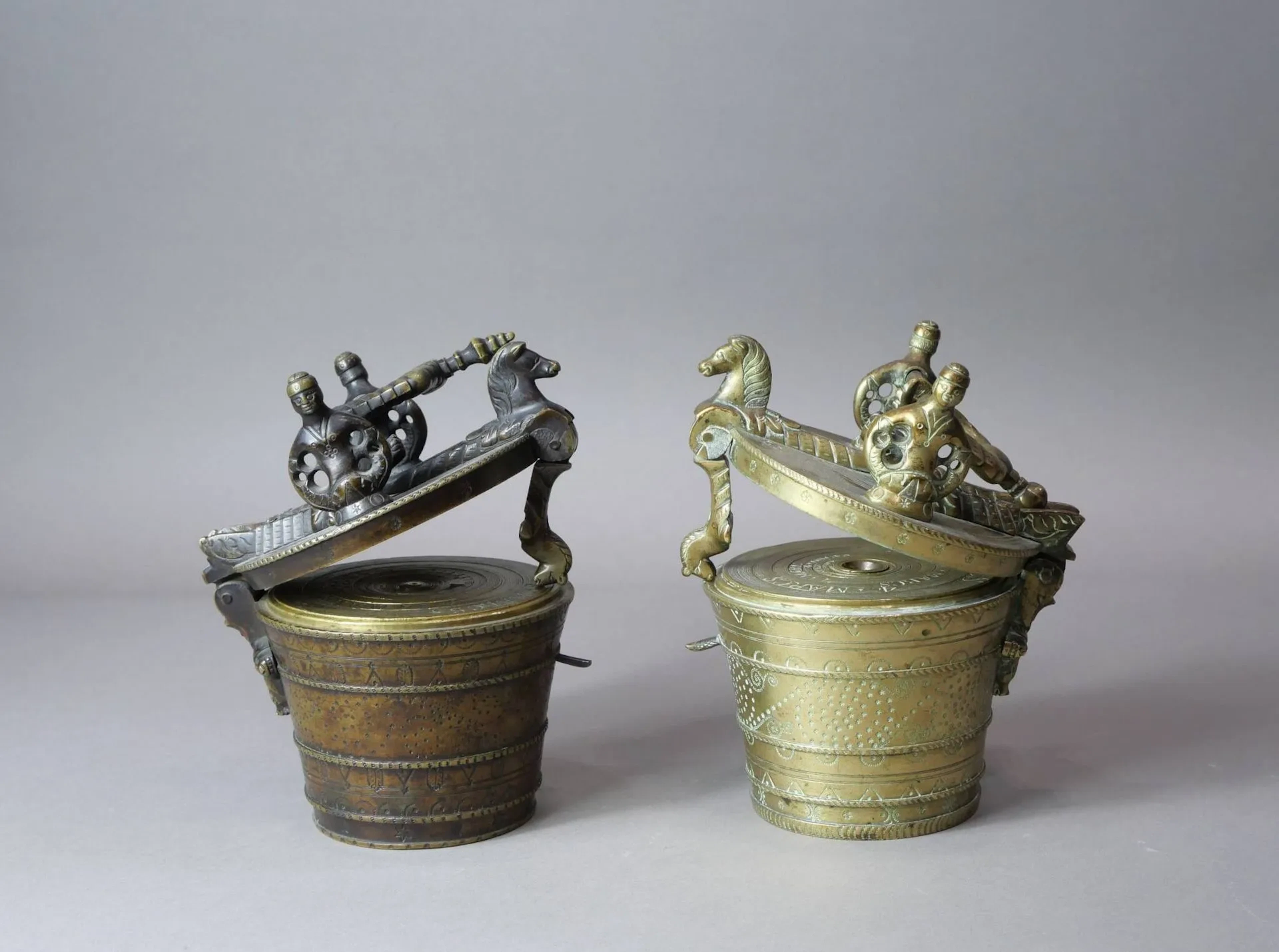 Deux piles de poids en bronze de 16 livres. Boîtier à décor de cinq champs poinçonnés de motifs géométriques, étoiles et demi-cercles. Poignée formée de deux serpents de mer affrontés, supports en forme de sirène à deux queues, charnière surmontée de deux lions de mer. Des chevaux marins formant moraillon et charnière. 1) Poinçon calice. Allemagne du sud, Nuremberg, Atelier Calice, probablement Johann Reichert (1761- 1768), seconde moitié du XVIIIe siècle Hauteur : 16,2 cm – Poids total : 7,8 kg 2) Poinçon calice. Allemagne du sud, Nuremberg, Atelier Calice, XVIIIe siècle Hauteur : 16,1 cm – Poids total : 7,8 kg (manque des godets et poids, réétalonné)