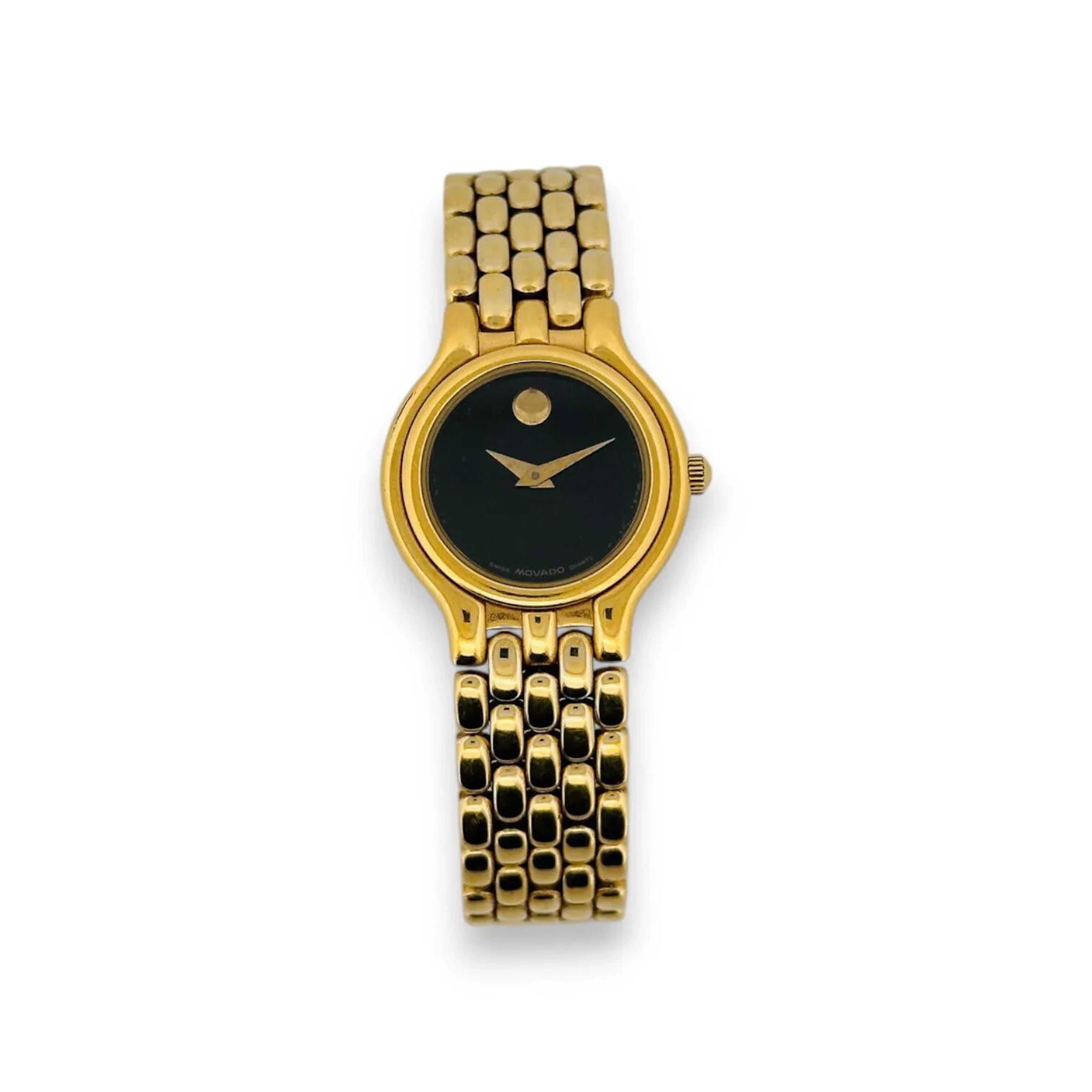 MOVADO Montre bracelet de femme en métal doré à boîtier circulaire et cadran noir. Cabochon de strass doré à 12h et aiguilles type Breguet. Bracelet en métal doré signé. Mouvement quartz Diam. 21 mm Deux maillons supplémentaires