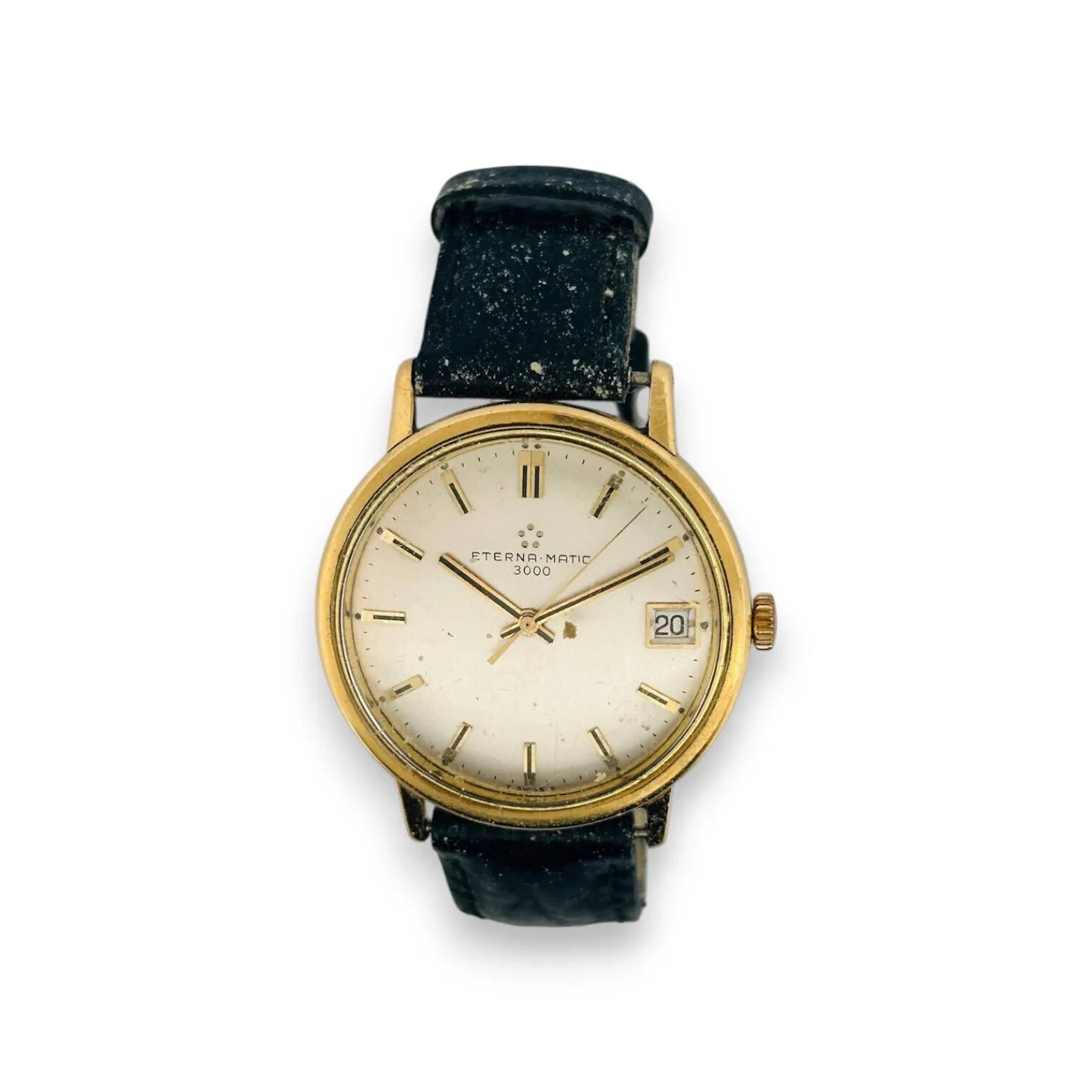 ETERNA MATIC 3000 Montre bracelet pour homme, boitier en or 18K (750), cadran champagne, index bâtons appliqués formant les heures, date par guichet à 3h, mouvement automatique, bracelet en cuir (très usé) à boucle ardillon en métal doré. Diam. : 34 mm - Poids brut : 36.58 g. (chocs, rayures)