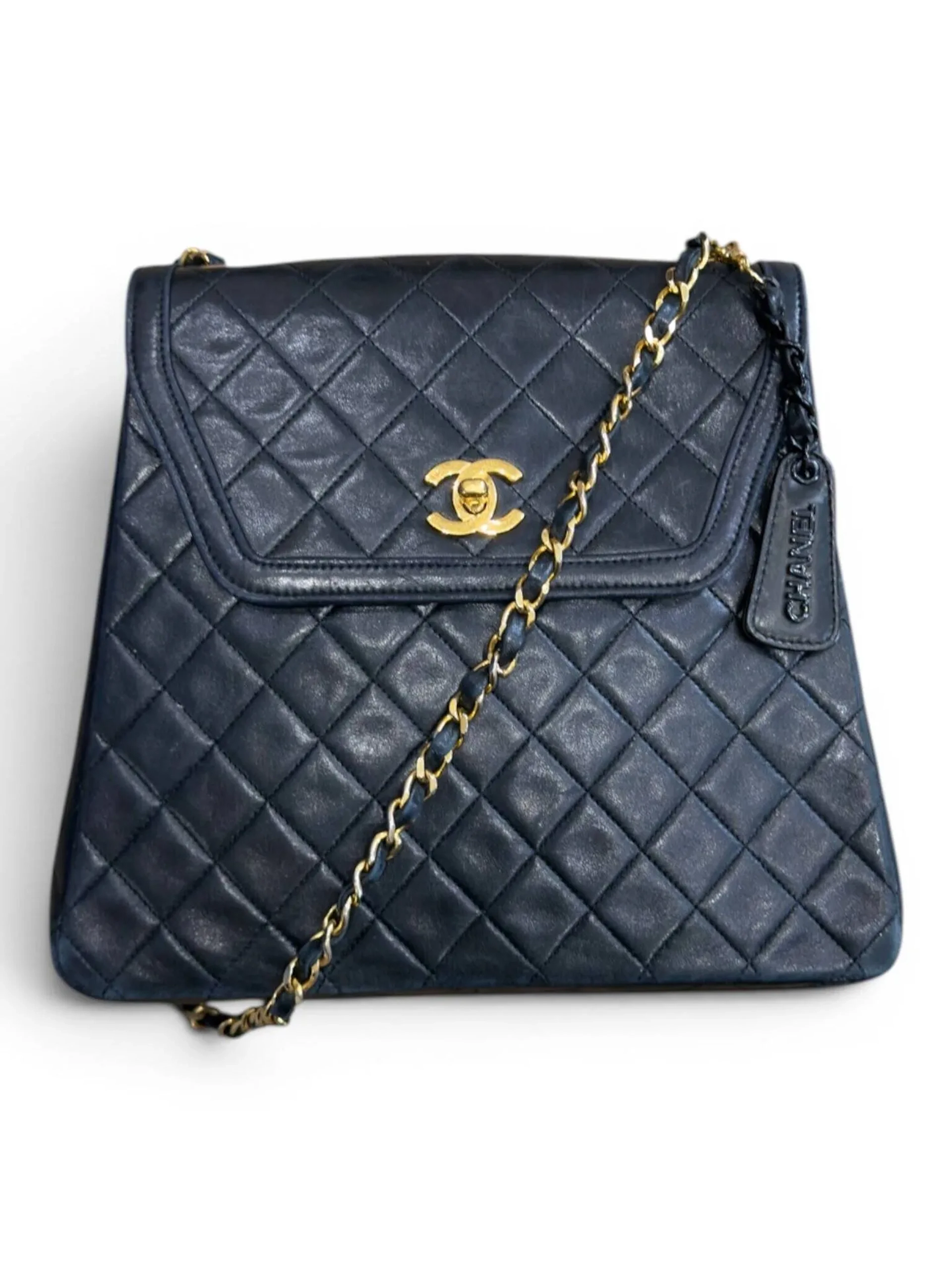 CHANEL Sac porté épaule à rabat en agneau matelassé bleu nuit, doublure en agneau bordeaux, bijouterie en métal plaqué or. Bon état, légers frottements aux angles, chaîne légèrement dédorée 25 x 22 x 6 cm Circa 1995