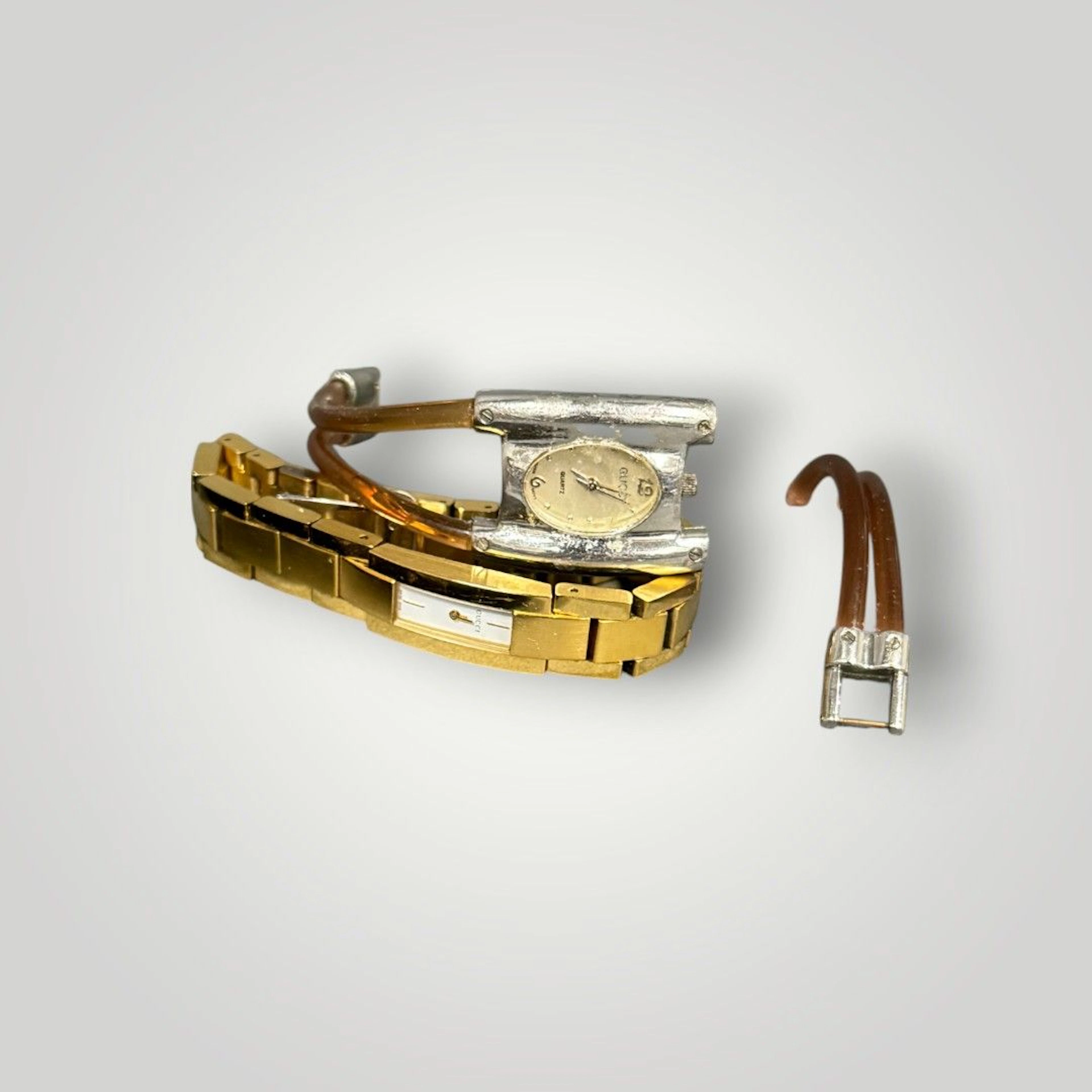 GUCCI Montre en acier doré à cadran rectangulaire émaillé, index à 6 et 12 heures. Boîtier signé Diam. intérieur: 5,3 cm environ Rayures On y joint une montre de la même marque accidentée