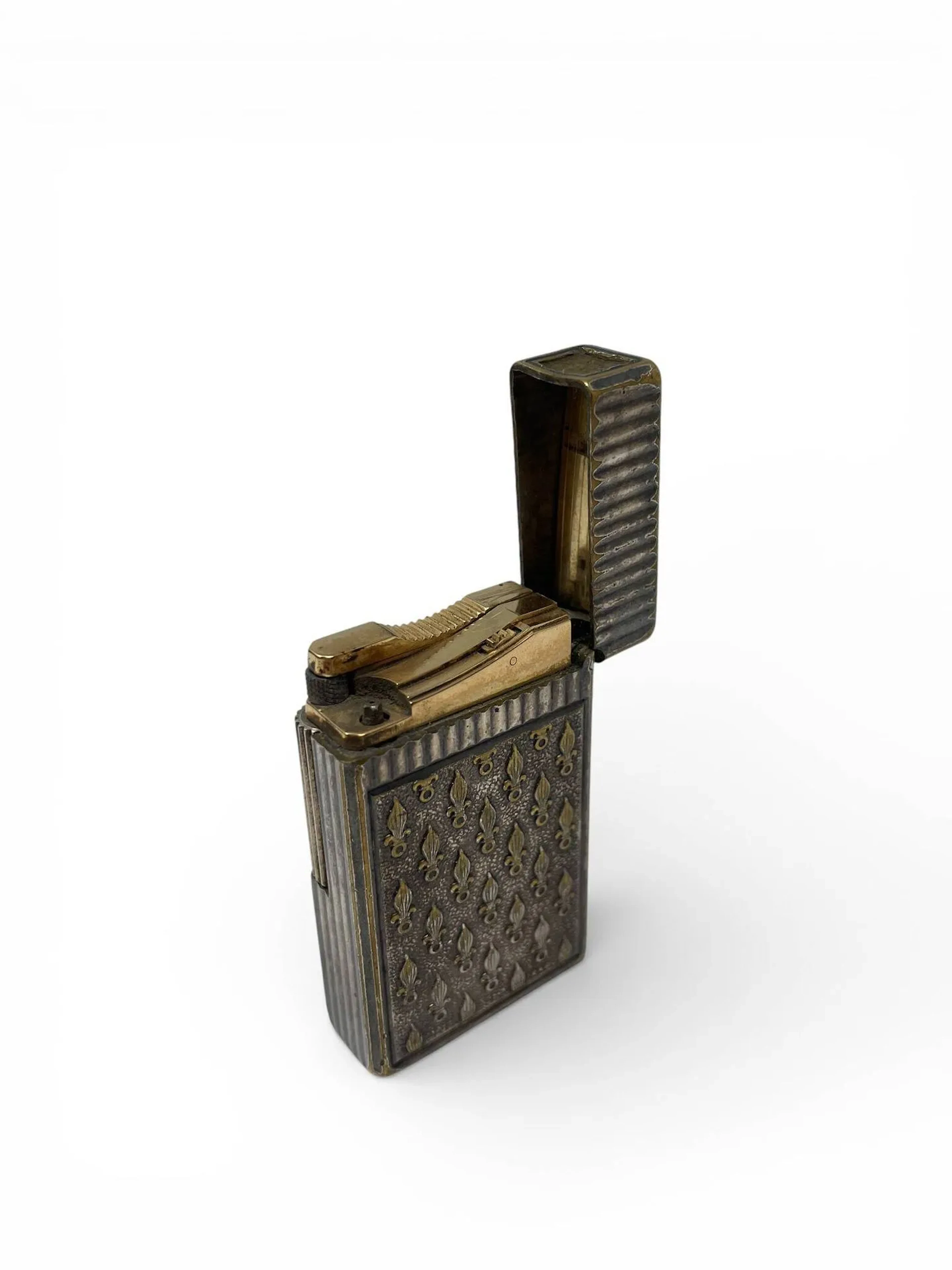 S.T. DUPONT Briquet en métal argenté à décor cannelé, l'un des plats à décor ciselé de grenades à sept flammes, emblèmes de la Légion Etrangère. Système à molette. Numéroté (en partie effacé) H. 5,7 - L. 3,4 cm Usures à l'argenture, chiffre peut être manquant