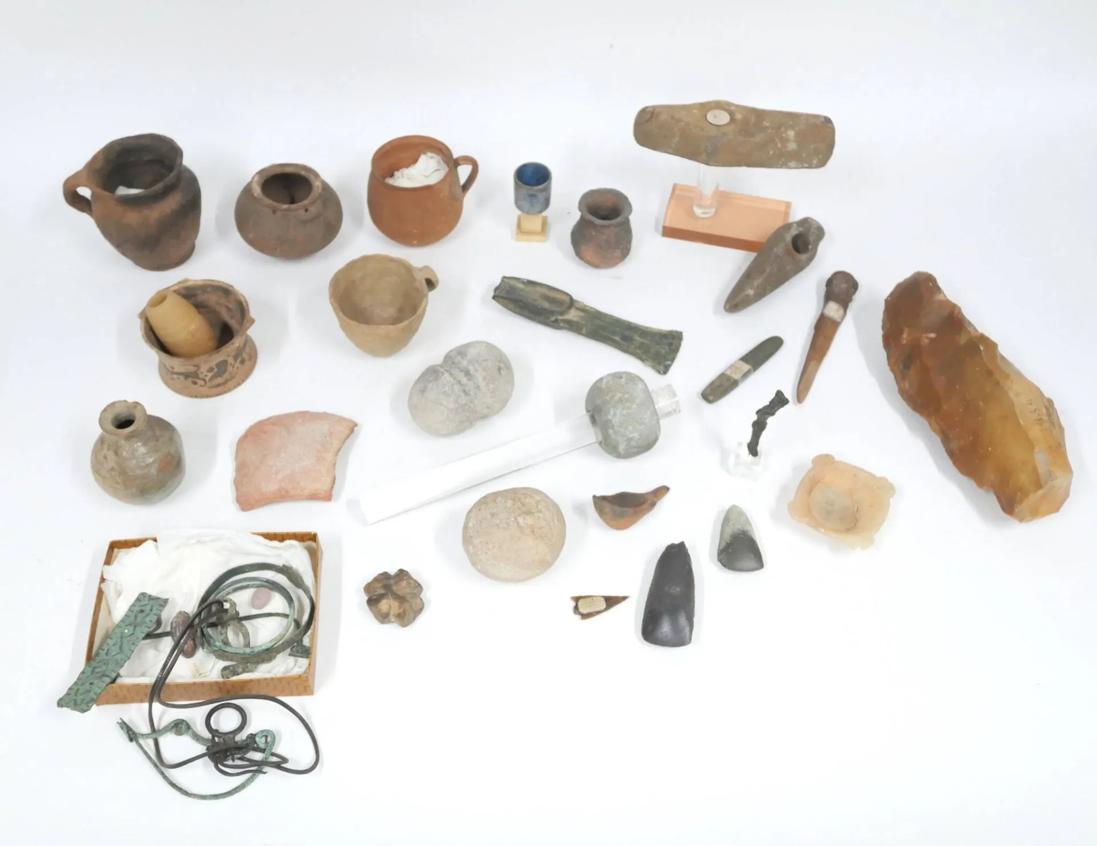 Bel ensemble de souvenirs de fouilles archéologiques dont pierres taillées, vases et coupes en terre cuite, hache en bronze, poignard en os, fragments de fibules ou bijoux... L hache bronze : 17,5 cm; poignard en os : 15,3 cm En l'état, sans garantie d'époque