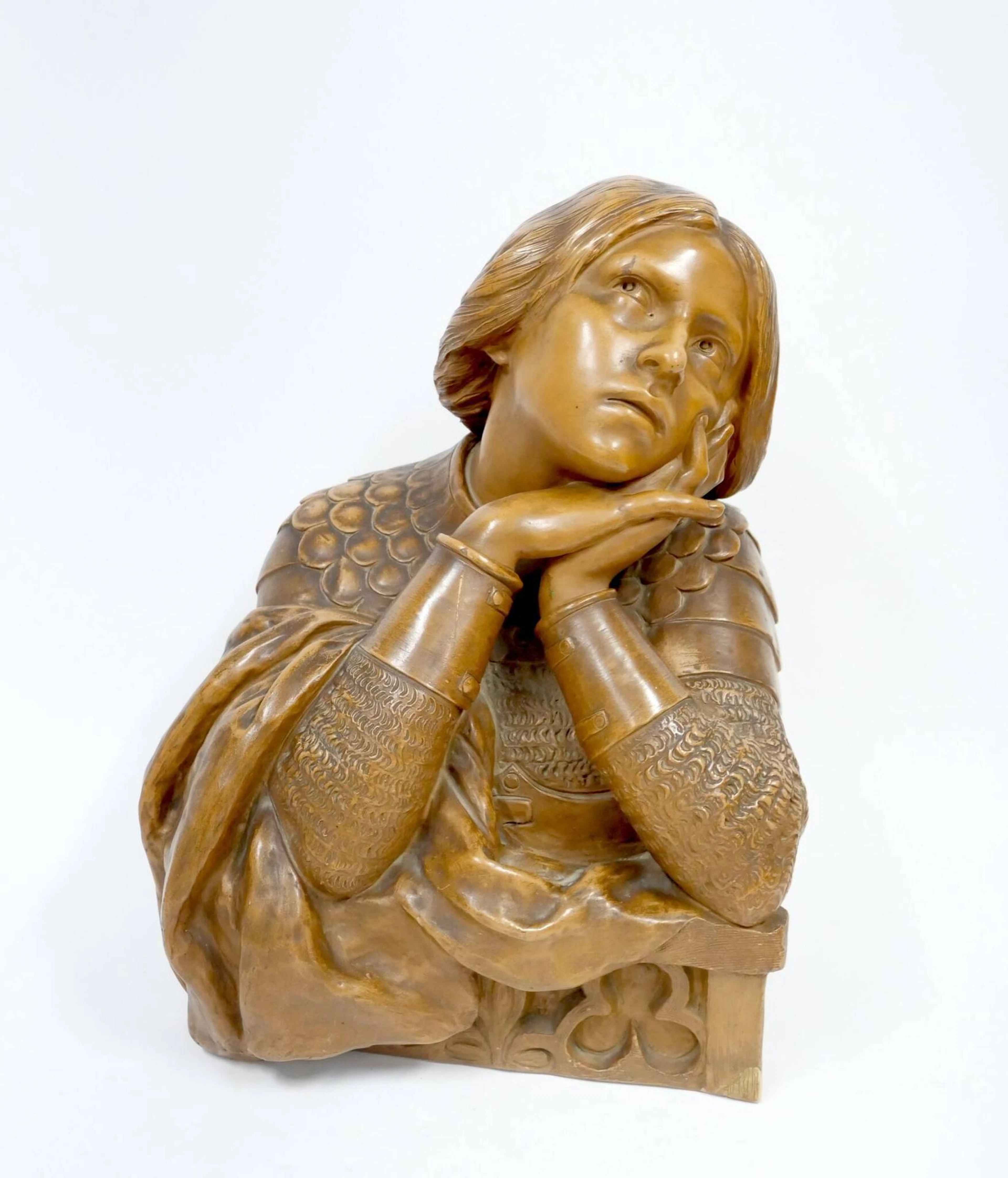 Charles MASSÉ (1855-1913) Buste de Jeanne d'Arc en armure, pensive, accoudée à une rambarde Terre cuite patinée Signé sur le côté et cachet "terre cuite de France" au dos H : 41 cm Griffure