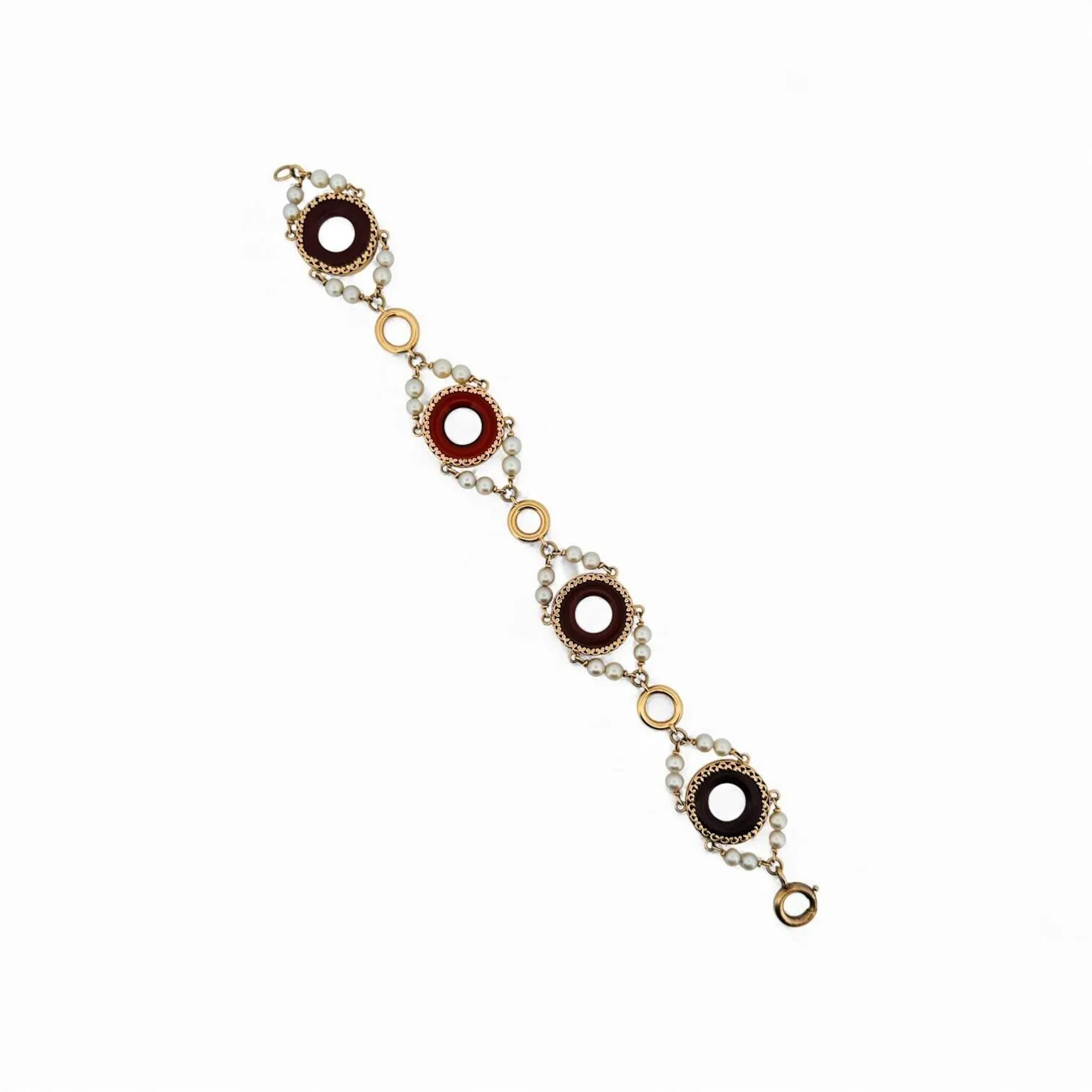 Bracelet en or jaune 18K (750) retenant des disques ajourés de cornalines épaulés de petites perles. Tour de poignet : 19 cm - Poids brut : 16.2 g. (petits enfoncements, chocs)