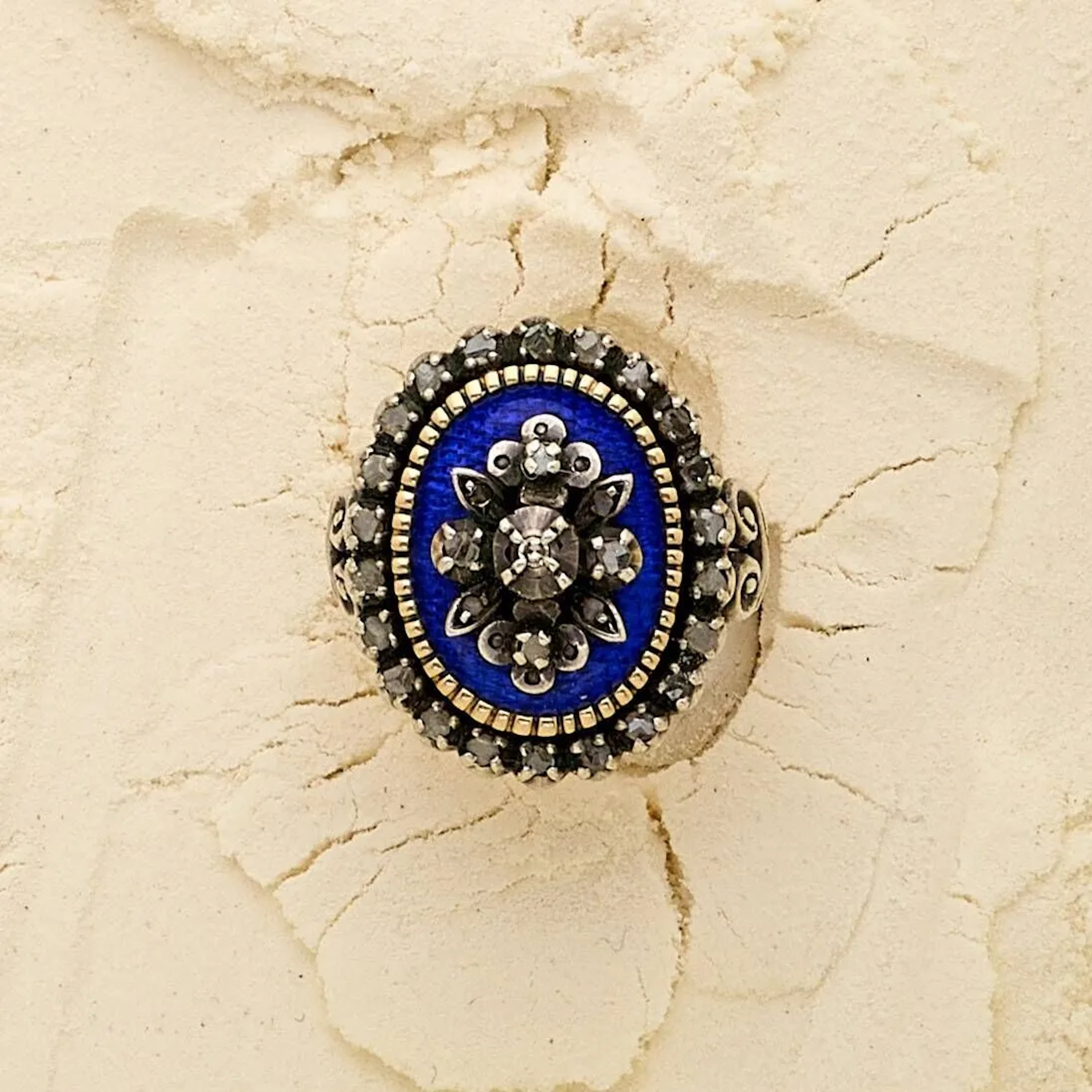 Bague marquise en or 18k (750e) et argent (800e), composée d'un plateau ovale émaillé bleu, appliquée d'un motif floral diamanté et entourée d'éclats de diamants. Travail étranger dans le goût du XIXème siècle. Poids brut: 9.70 g. Tour de doigt: 51.5