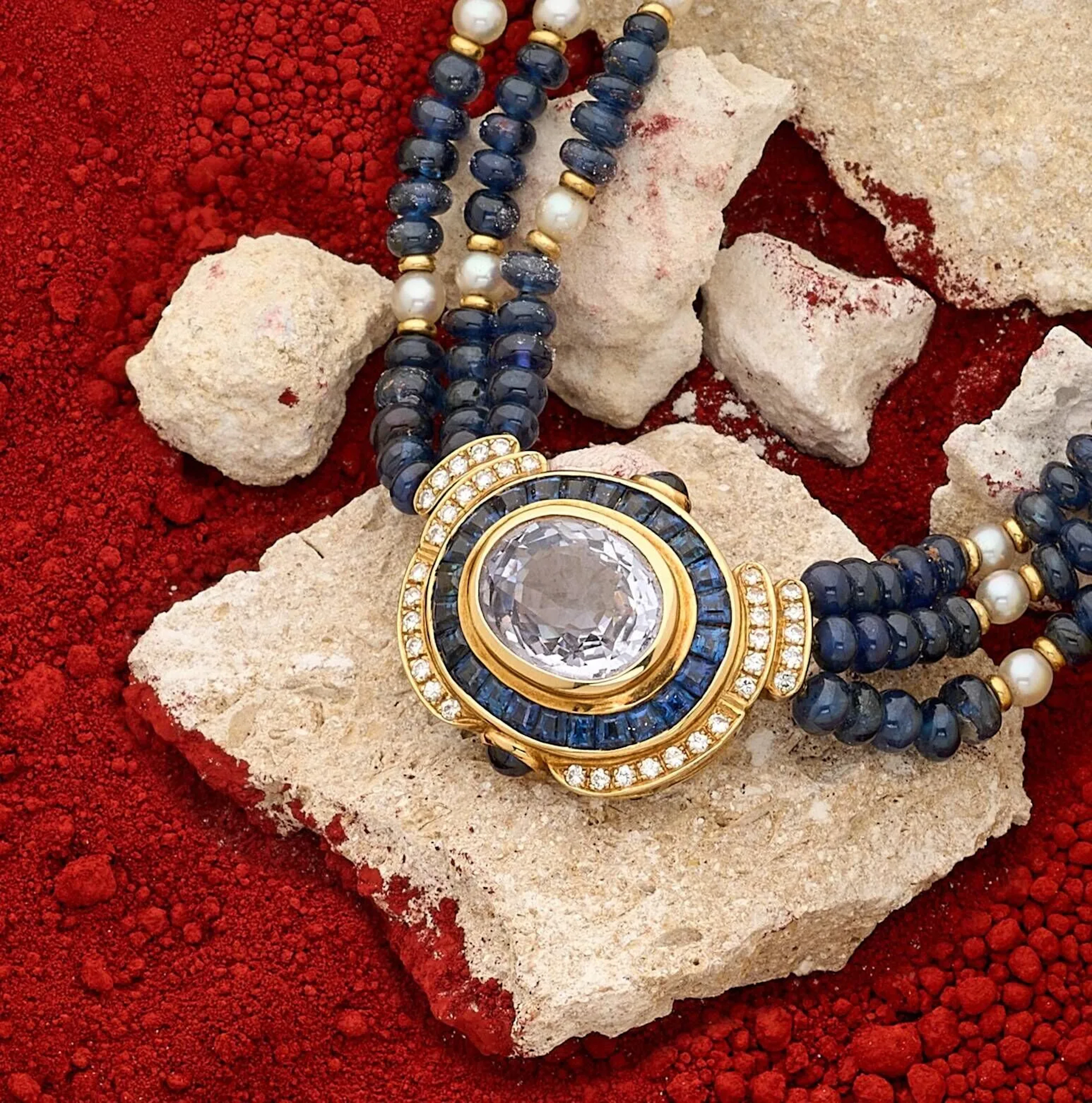 Collier ras de cou en or 18k (750e), composé de 3 rangs de perles de saphir alternées de rondelles en or 18k (750e) et perles de culture, le fermoir à cliquet en or 18k (750e) centré d'un saphir ovale coussin en serti clos dans un double entourage de calibrés de saphirs et diamants brillantés. Poids du saphir principal : 8.86 carats. Non chauffé. Poids brut : 46.20 g. Accompagné d'un examen préliminaire du LFG n°422369 daté du 16/12/2025 et d'une facture d'achat datée de 1986. Longueur : 36 cm