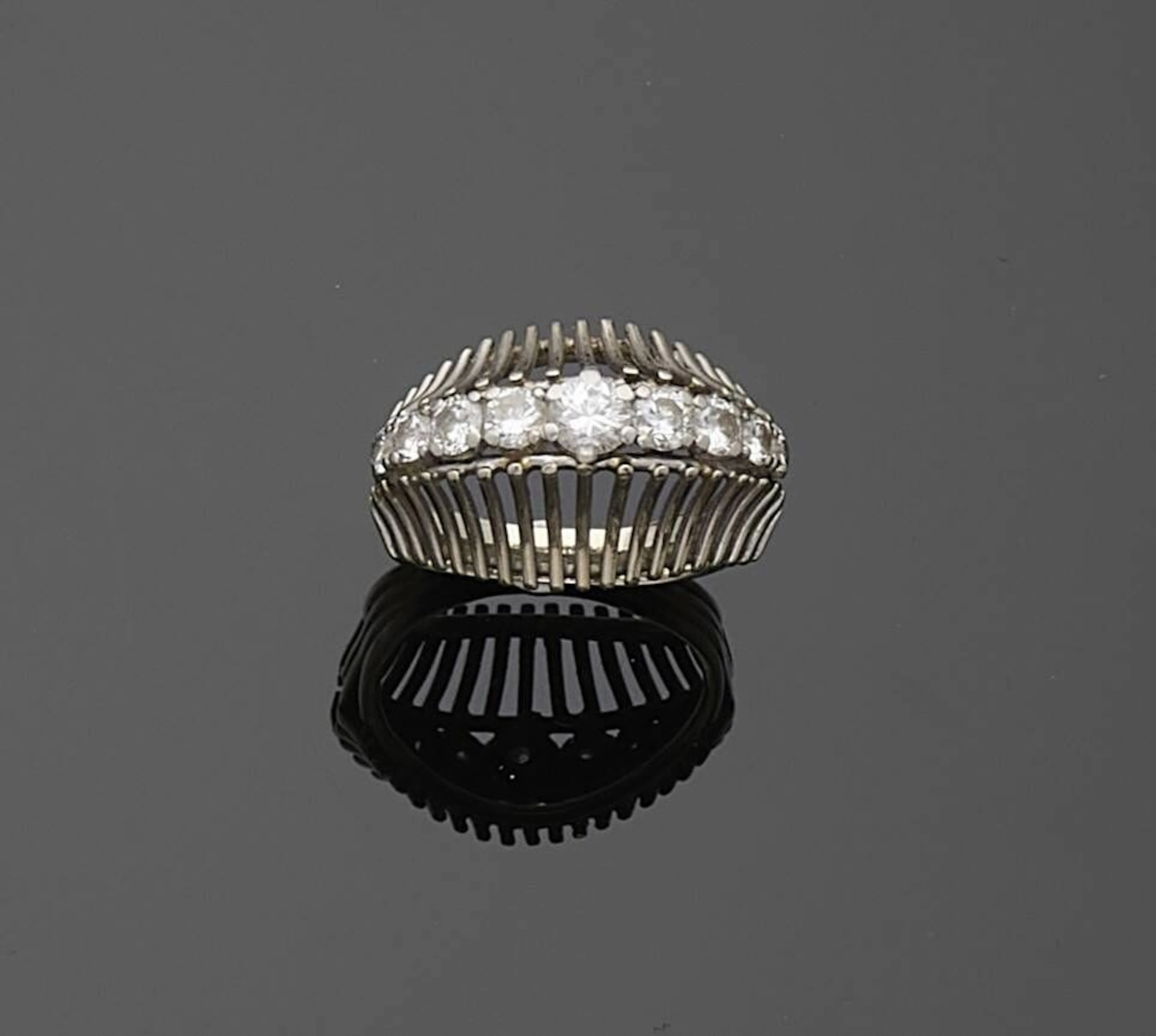 Bague en fils de platine, sertie d'une ligne de diamants ronds de taille brillant en chute. Travail français des années 1950. Tour de doigt : 53. Poids brut : 6 g