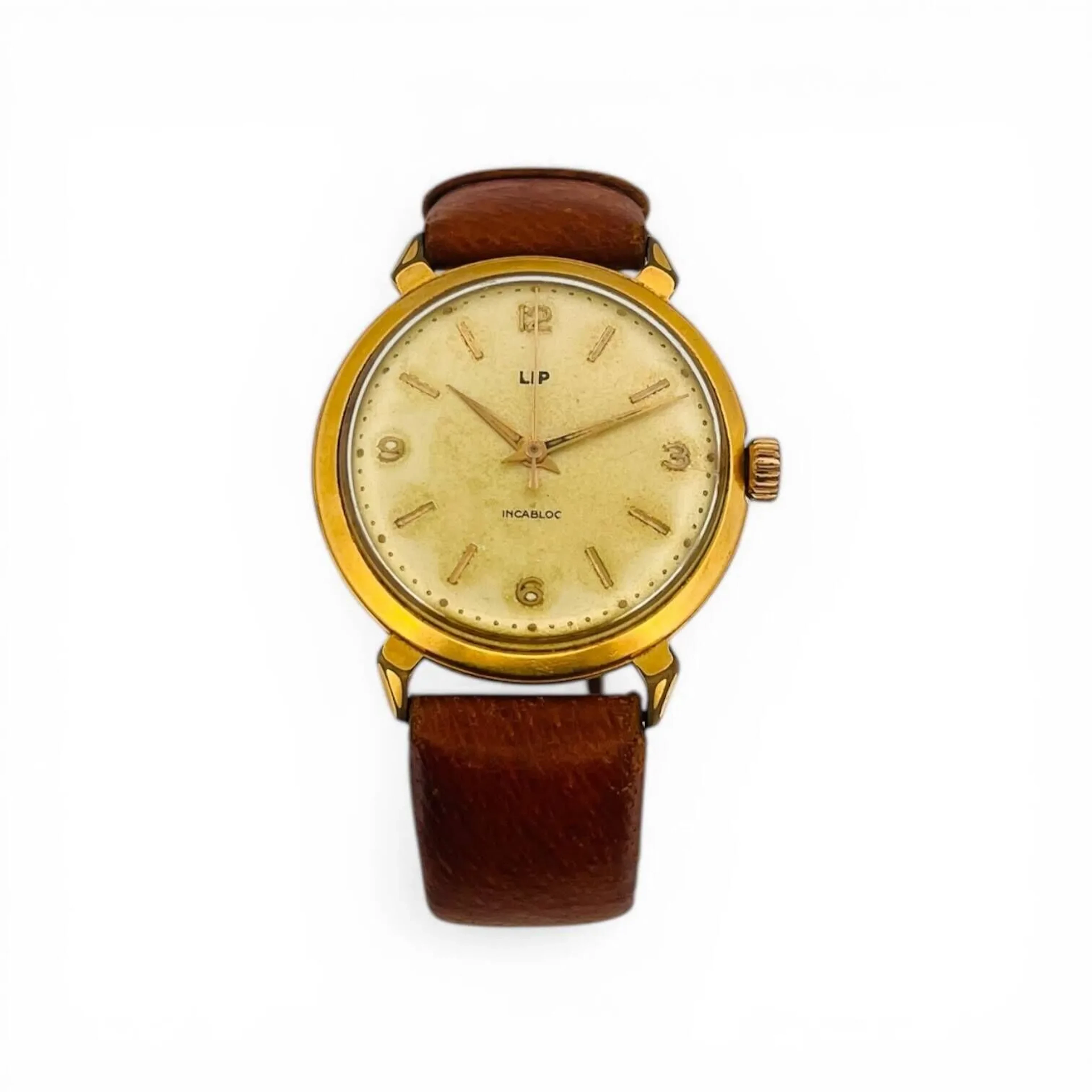 LIP Montre bracelet d'homme en métal doré à cadran champagne, chiffres arabes pour les heures et index appliqués dorés. Fond de boîtier vissé en acier signé et numéroté 523672. Mouvement mécanique à remontage manuel Diam. 35 mm Montre fonctionnelle au moment de l'expertise, rayures à la glace, usures à la couronne, bracelet rapporté en cuir à boucle ardillon dorée