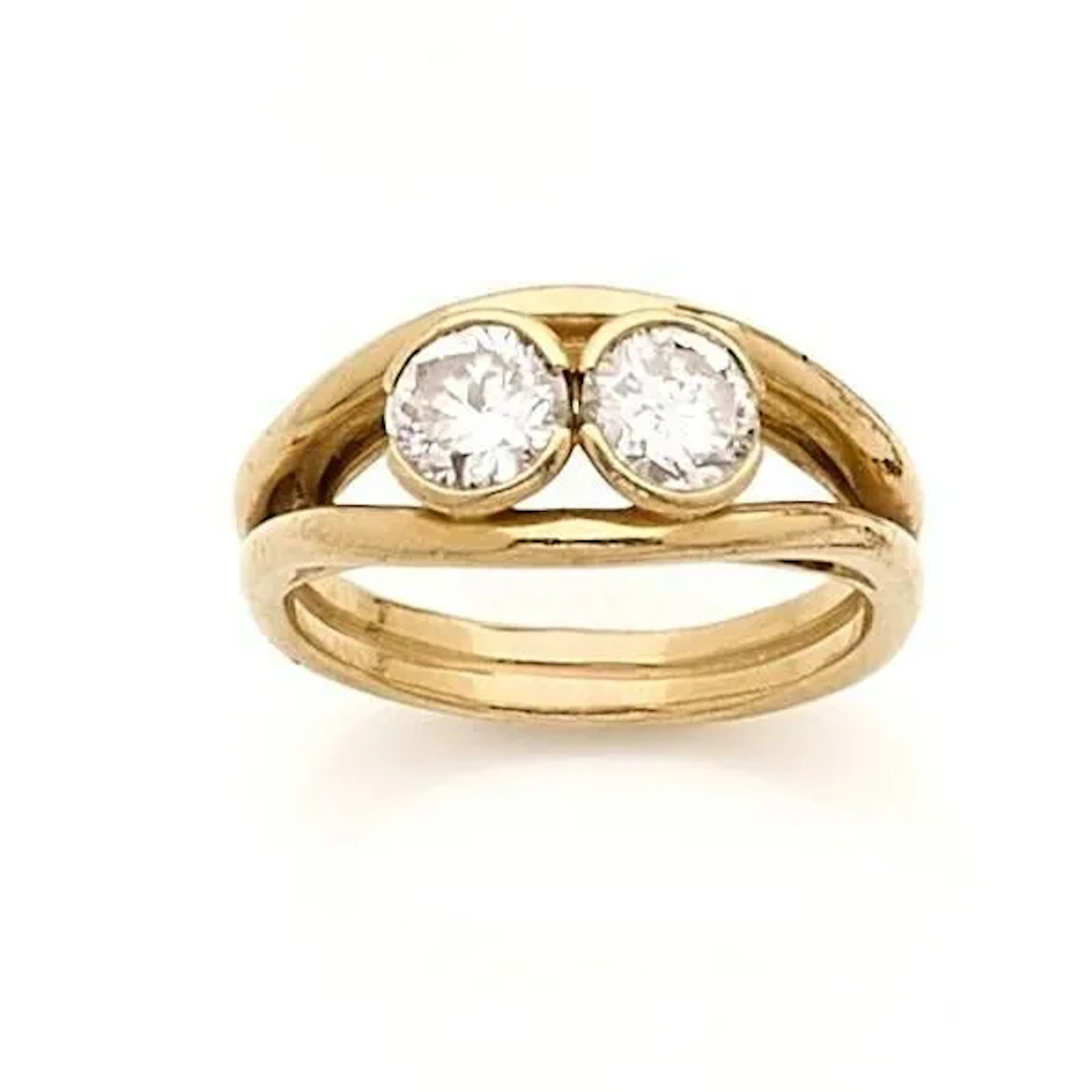 Bague jonc ajourée en or 18k (750e), ornée de 2 diamants taille ancienne en demi serti clos, bordée de fils godronnés. Poids des diamants : 1.50 carats environ l'ensemble. Poids brut : 9.30 g. Tour de doigt : 59.