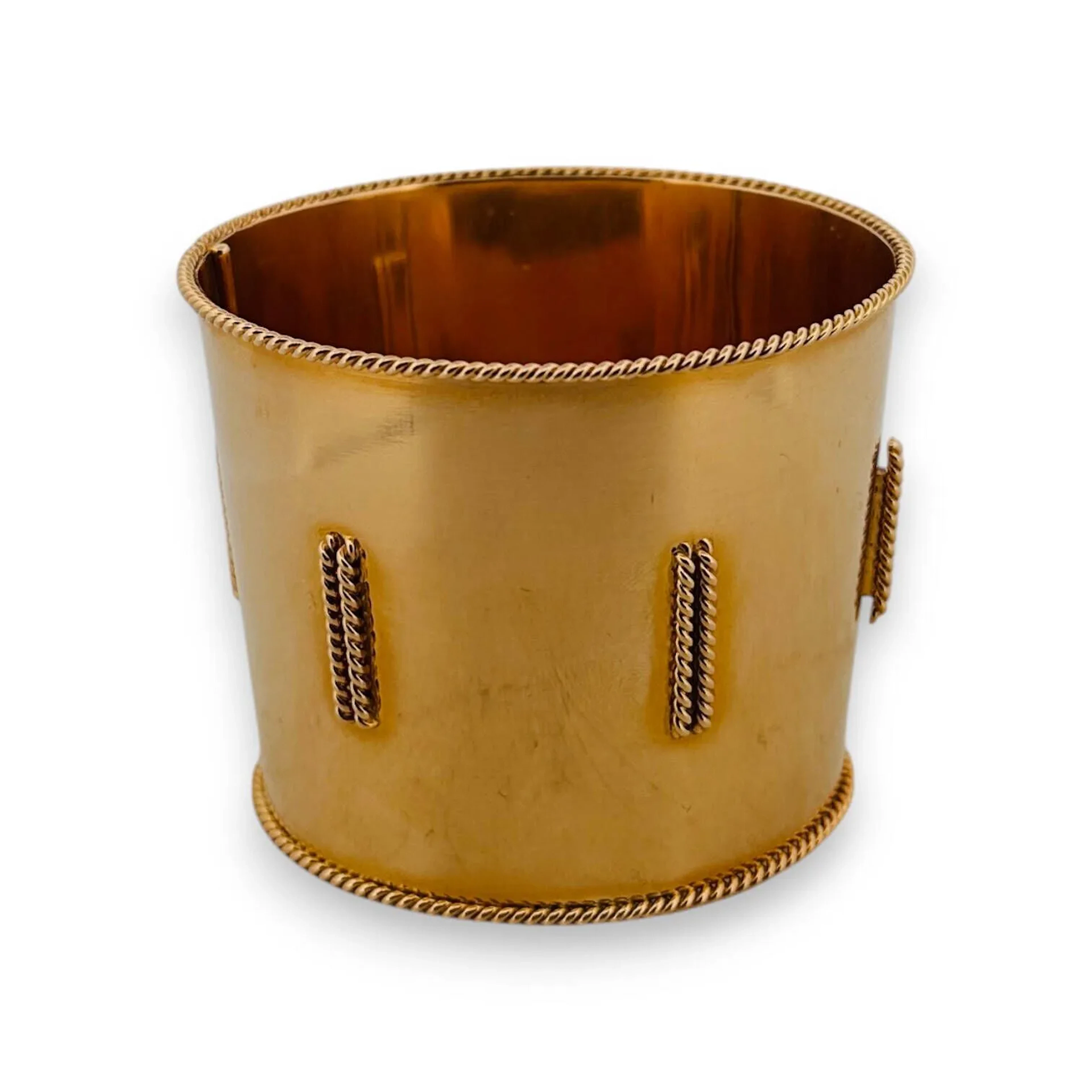 Important bracelet manchette ouvrant en or 18k (750e) de forme conique, à décor de double agrafes torsadées, les bordures au même décor. Il est agrémenté d’un fermoir à cliquet invisible. (bel état) Il est accompagné de son écrin à la forme, de la maison Les Heures d’or à Paris. Poids : 122 g. Largeur : 5.5 cm. Dimensions internes : 6 à 6.5 cm.