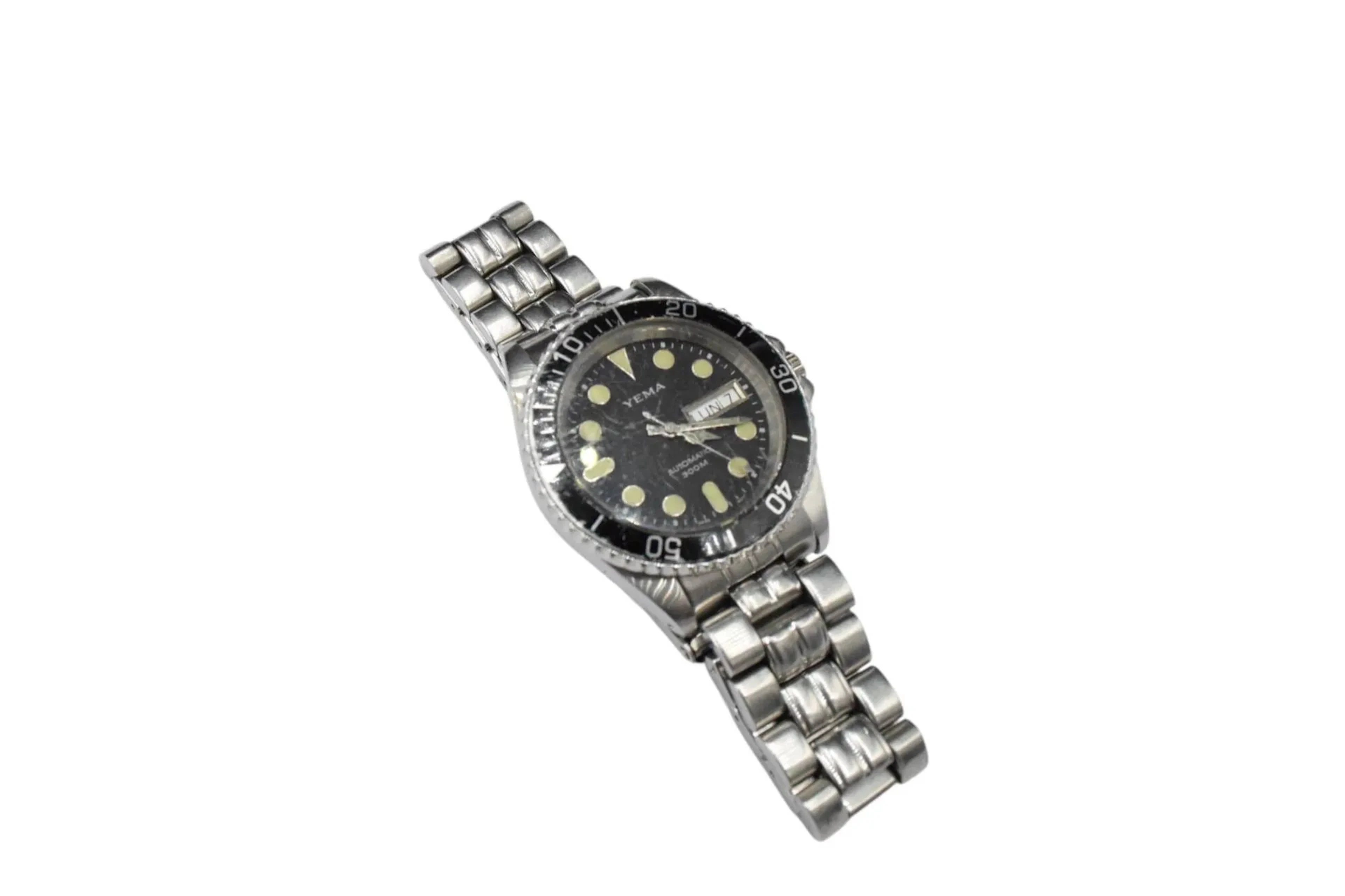YEMA Montre bracelet d'homme en acier, cadran noir, lunette tournante graduée, index points formant les heures, guichet date à 3h, mouvement automatique, bracelet intégré en acier à boucle déployante siglée. Cadran et boitier signés. Diam. : 38 mm (rayures au verre, micro rayures d'usage au bracelet)