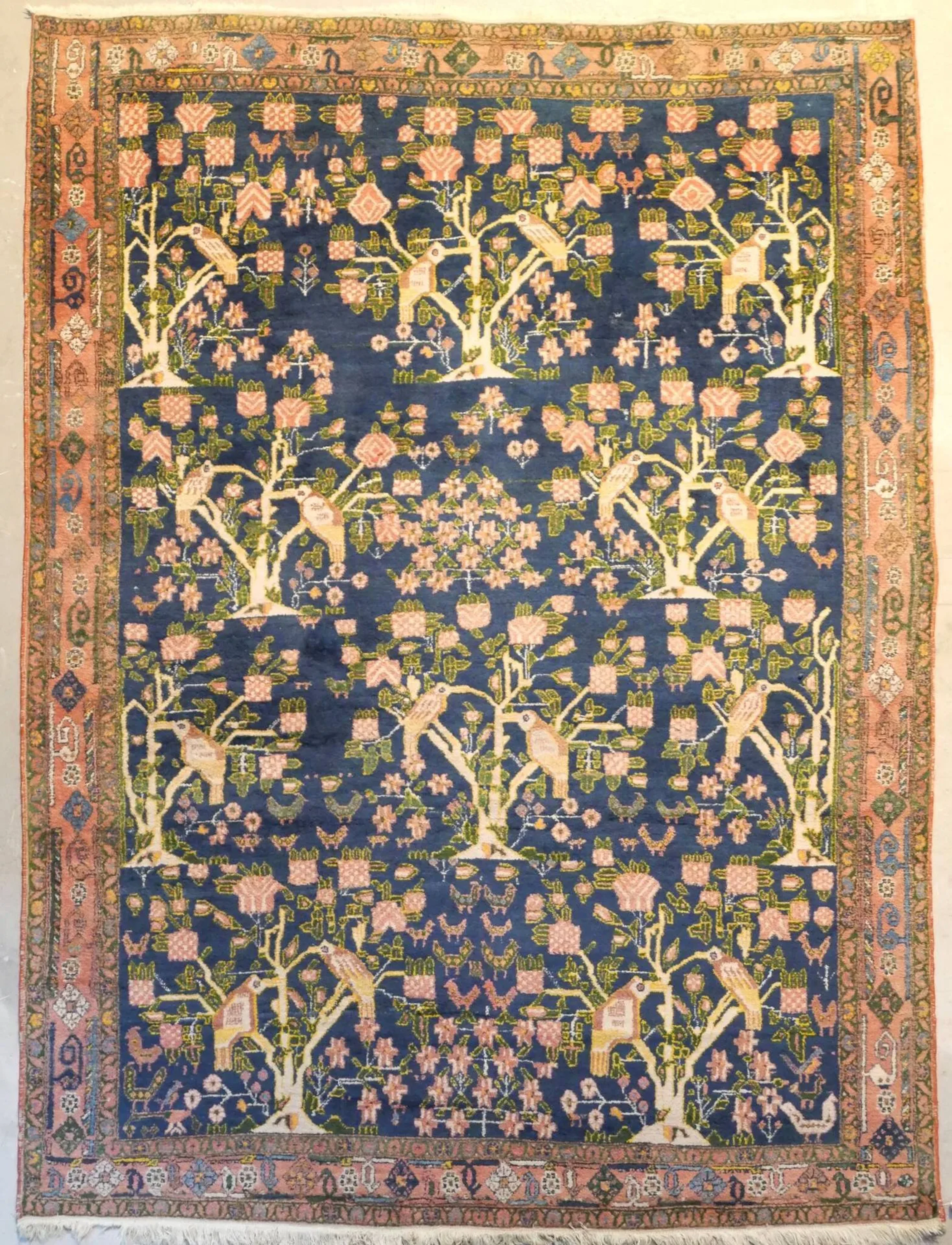 Original Afchar Iran Vers 1960 Dimensions 217 x 159 cm Velours de laine sur fondations en coton Bon état général Belle finesse Champ bleu de Prusse à original décor de rangées d'arbres de vie richement fleuris à volatiles stylisés (perroquets), plantes et compositions de fleurs géométriques, ivoire et rose pâle entourées de feuillages vert amande. Triple bordures dont la principale rose pâle à décor de semis de boutons floraux en forme de diamants stylisés Bibliographie : Roger Bechirian, Enza Milanesi , J.Anquetil, Doris Eider