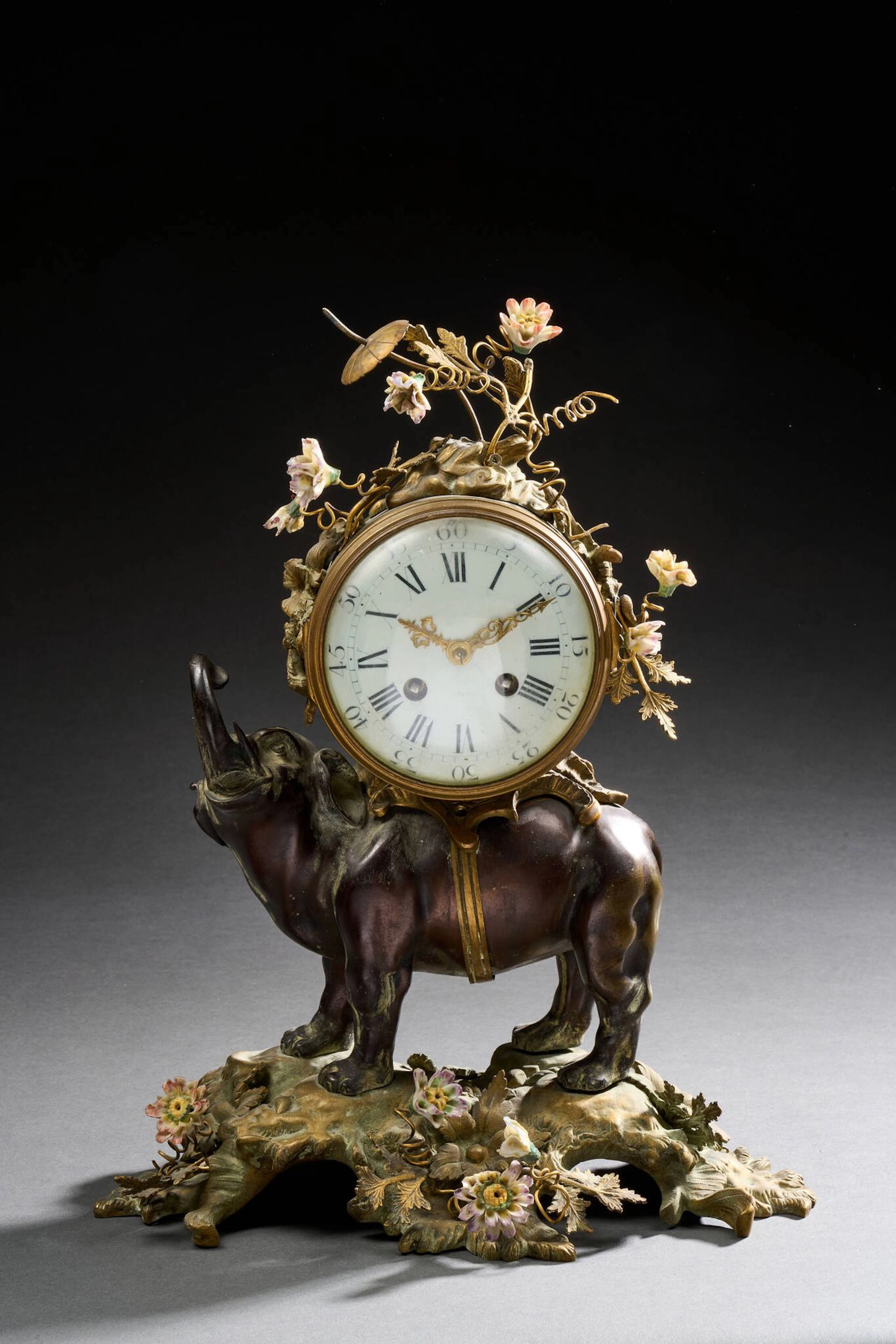 Clock featuring a bronze elephant carrying a load, with a br - Lot 220