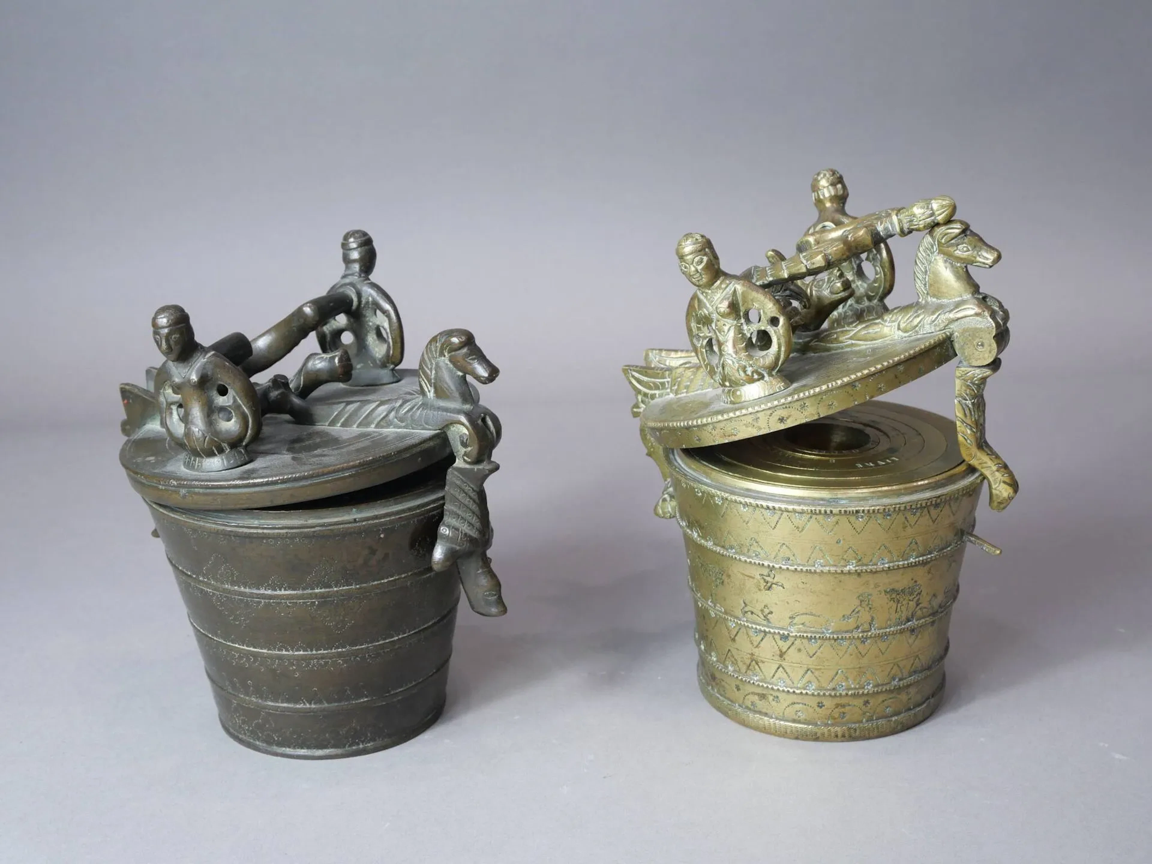 Deux piles de poids en bronze de 16 livres. 1) Inscriptions et marques XVI MARCS et fleur de lys de la Cour des Monnaies au fond de la boîte. Motifs géométriques sur le boîtier divisé en cinq champs. Poignée formée de deux serpents de mer affrontés surmontés d’une couronne, supports en forme de sirène à deux queues. Des chevaux marins formant moraillon et charnière. Allemagne du sud, Nuremberg, XVIIe siècle Hauteur : 16,8 cm - Poids : 7,578 kg (accidents et manques dont un godet et poids) Provenance : vente Artcurial 2) Poinçon Flèche et clef IWZ. Scène de chasse et motifs géométriques sur le boîtier divisé en cinq champs. Poignée formée de deux serpents de mer affrontés surmontés d’une couronne, supports en forme de sirène à deux queues. Des chevaux marins formant moraillon et charnière. Allemagne du sud, Nuremberg, Maître balancier Johann Wolfgang Zickengeist (1704-1746), première moitié du XVIIIe siècle Hauteur : 16,6 cm – Poids total : 7,7 kg (manques dont un godet et des poids)