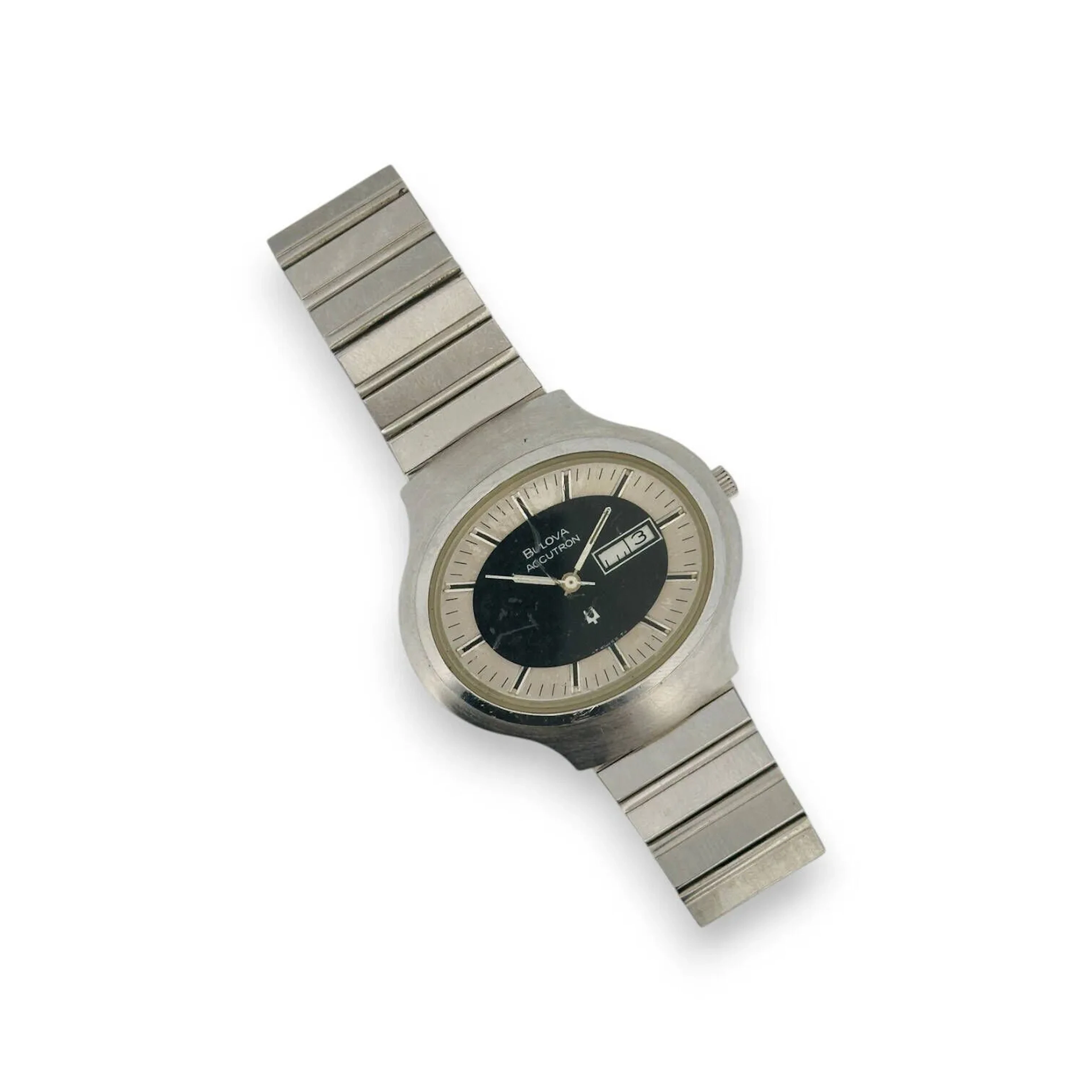 BULOVA Accutron Montre bracelet pour homme, boitier ovale en acier, cadran noir et argenté, index bâtons formant les heures, jour et date par guichet à 3h, mouvement quartz (pile non vérifiée), bracelet rapporté en acier à boucle déployante. (rayures et chocs)