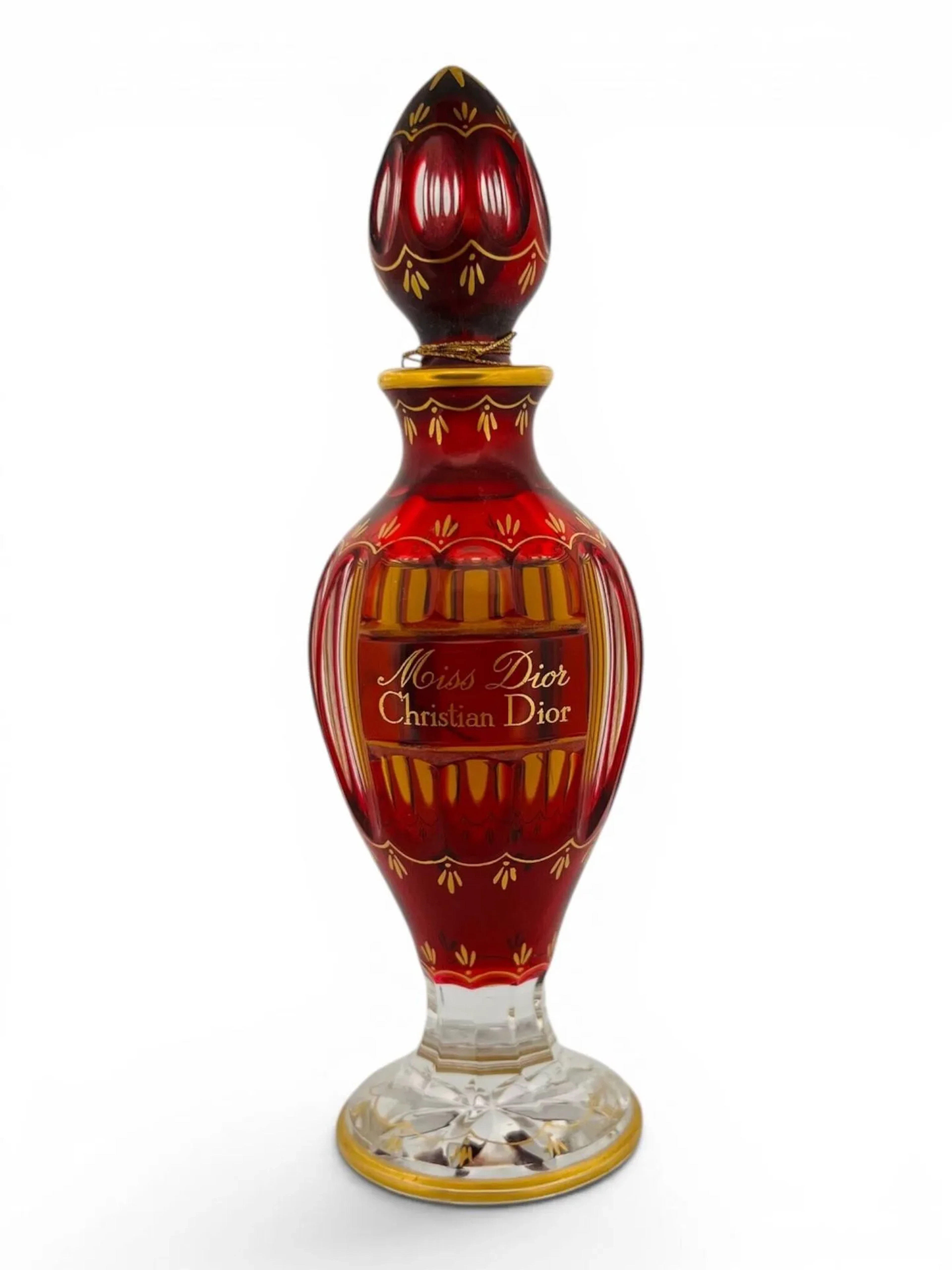 BACCARAT pour Christian DIOR Miss Dior Flacon amphore sur piédouche en cristal overlay rouge à rehauts dorés. Bouchon olive scellé. Tampon Baccarat sur le dessous H. 17,5 cm Légères usures Dans sa boite en carton gainé de velours et satin rouge à passementerie, avec carte de visite de la cristallerie (usures)