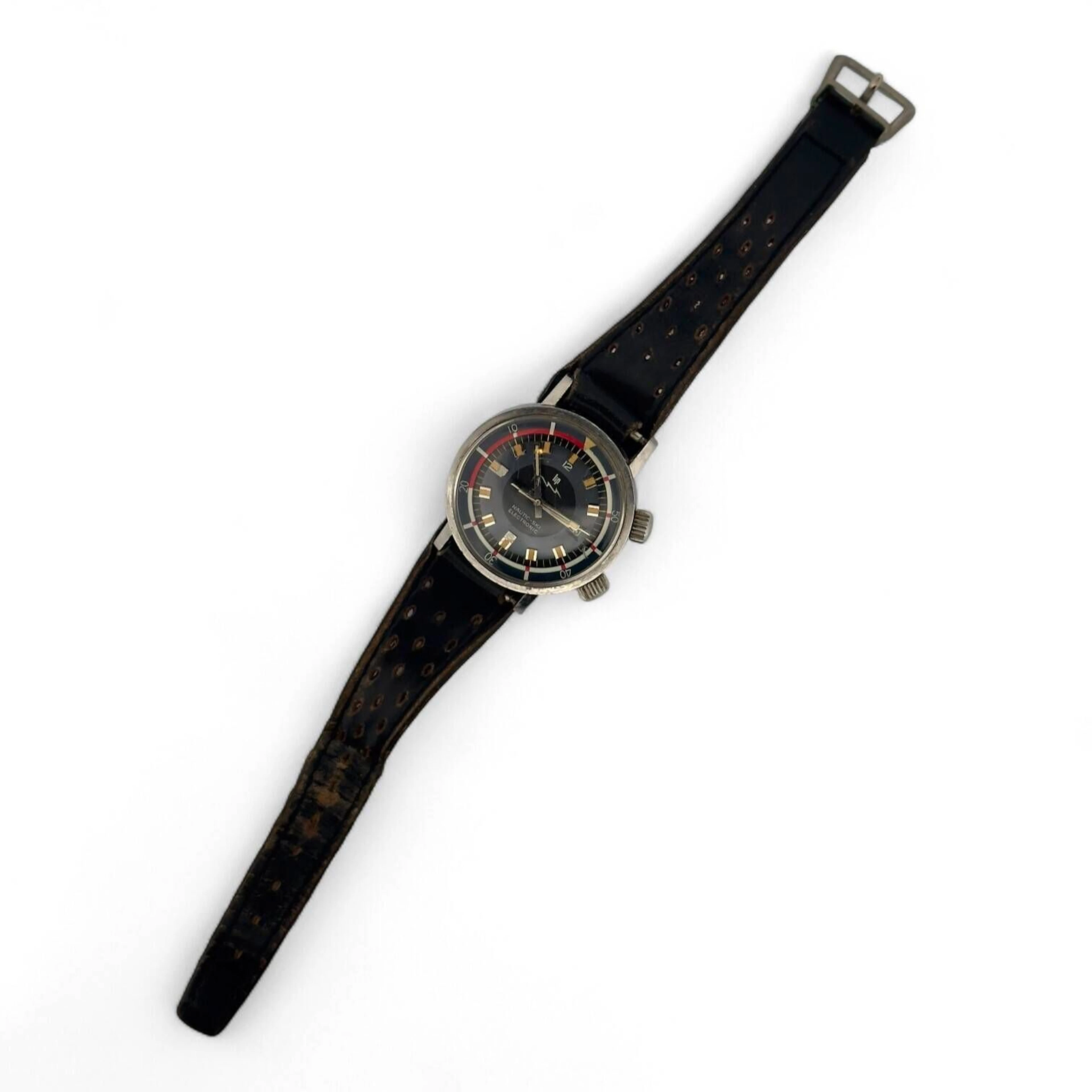 LIP NAUTIC-SKIELECTRONIC Montre bracelet d’homme en acier, cadran bleu, index bâtons en appliques argentées et matière luminescente tritium, lunette tournante interne bidirectionnelle, aiguilles bâtons argentées avec matière luminescente, aiguille des secondes lollipop rectangulaire. Fond en acier vissé signé LIP, numéroté 929784. Mouvement électro-mécanique. Bracelet en cuir noir, boucle ardillon en métal. Mouvement non fonctionnel lors de l’expertise, sans garantie de fonctionnement futur et d’état des pièces. Rayures au boitier et au verre. Accompagnée d’une boite de montre LIP. Diamètre 36 mm Vers 1970